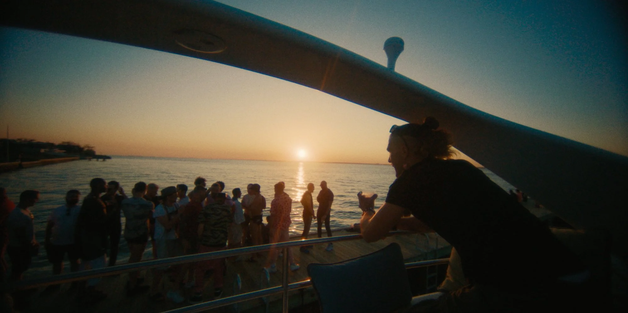 People on a boat watching a sunset over the ocean.