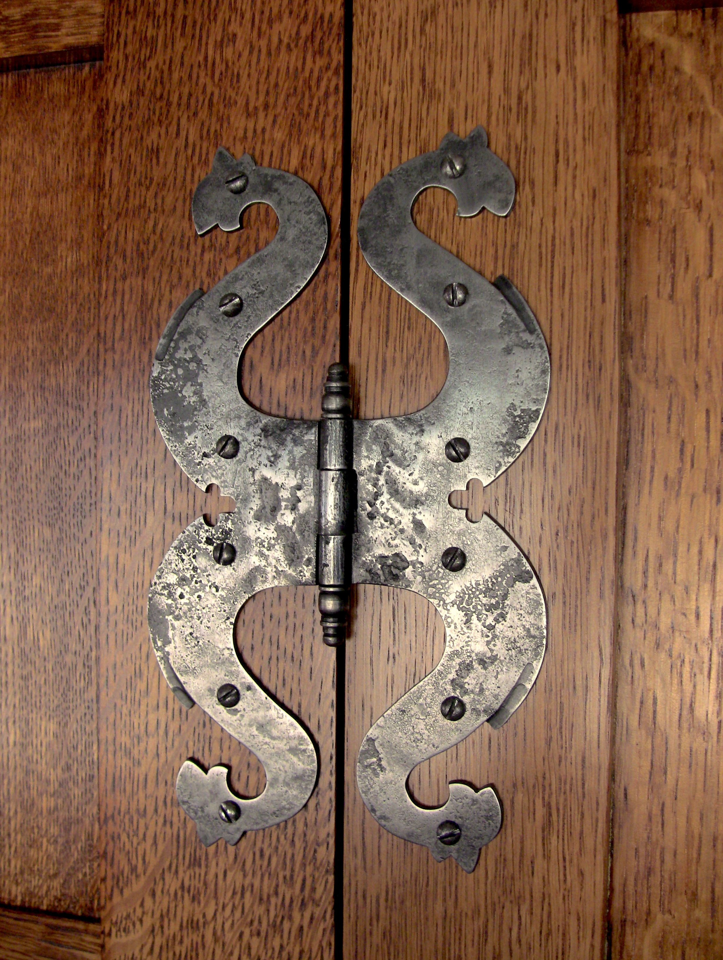 The paneling and custom made iron dragon's head hinges are replicas of the "Best Dressing Room" at Lutyens' Castle Drogo.
