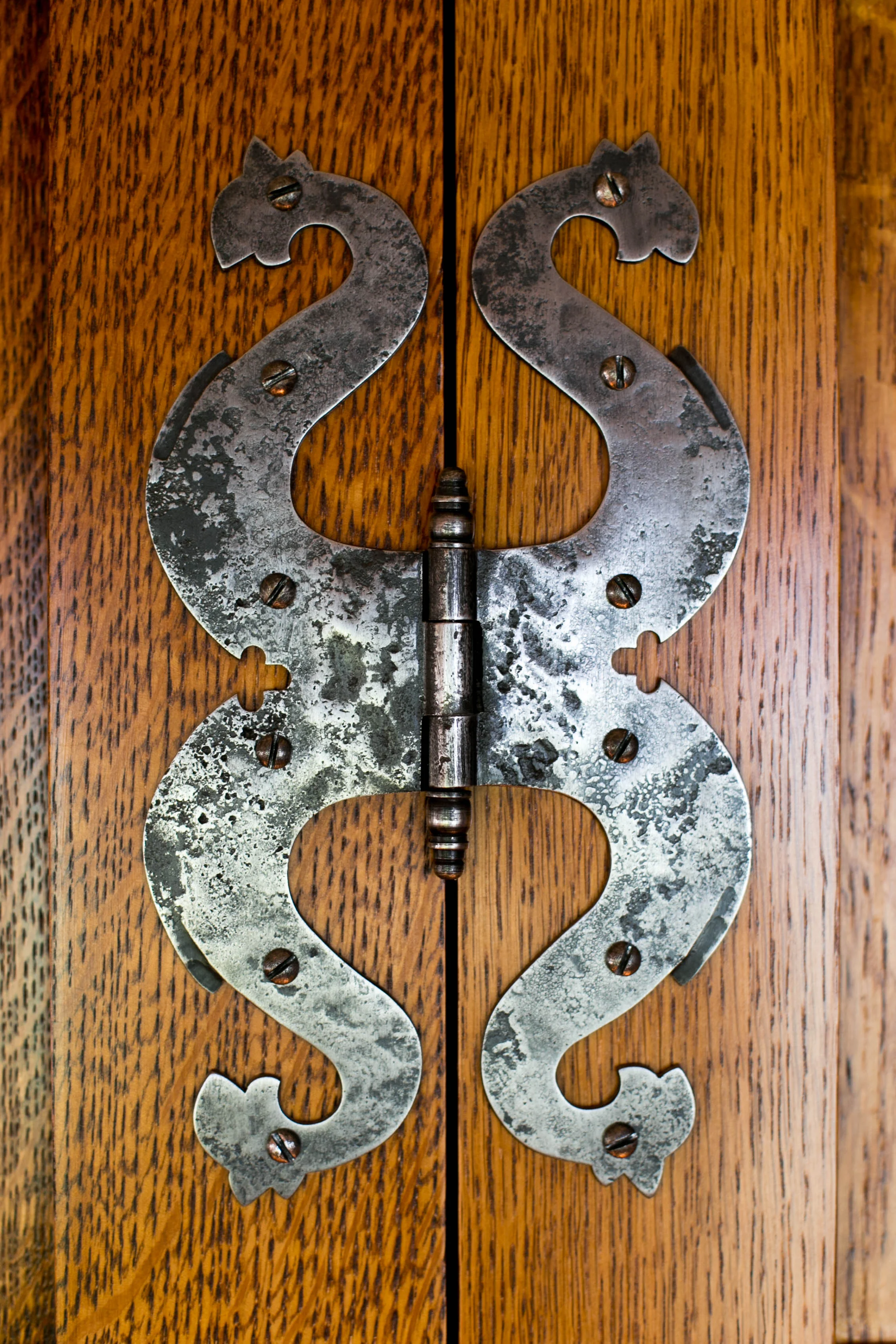 Custom made reproduction dragon's head butterfly hinges. The paneling and hinges are replicas of the "Best Dressing Room" at Lutyens' Castle Drogo.