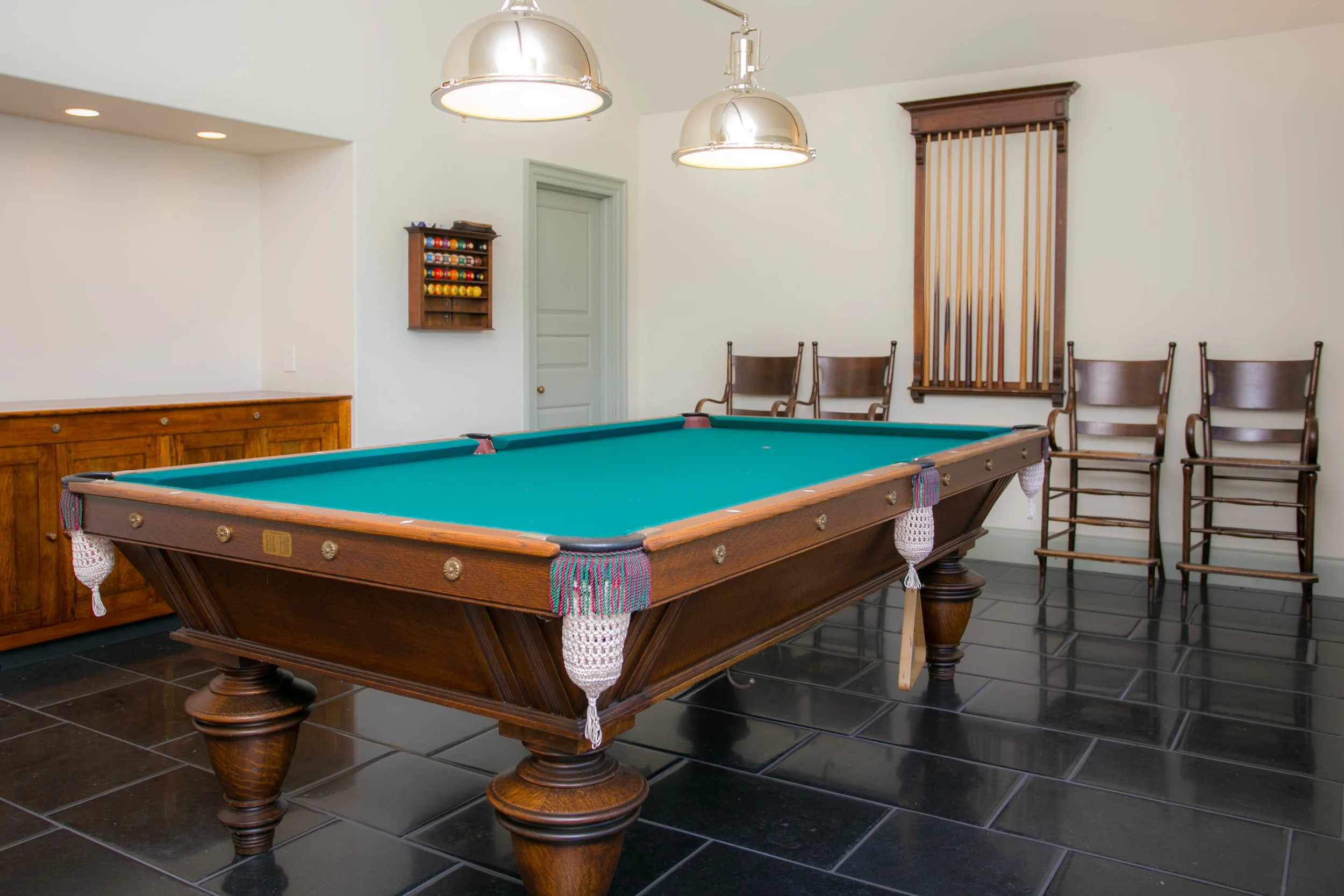 Custom pillow edged Irish blue limestone flooring, quarter-sawn oak cabinetry, bespoke pooltable lights and cathedral ceiling