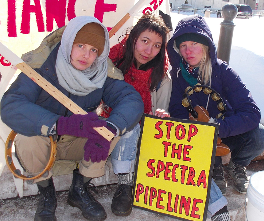 Anya Klepacki, left, Claire Sowa, middle, and Nelli Routsalainen of Stop the West Roxbury Lateral Pipeline outside the Rhode Island Statehouse during a March 6 protest. (Tim Faulkner/ecoRI News)