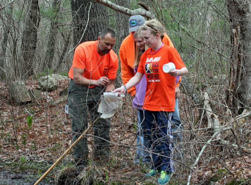 Chariho Middle School science teacher Daniel Potts, left, looks at the contents of a dip net gathered by students Emily Stevens, center, and Ashley Nelson. In the back is Ed Walsh, from Trout Unlimited, who along with Jay Boyer, teach a fly-tying class at the school.