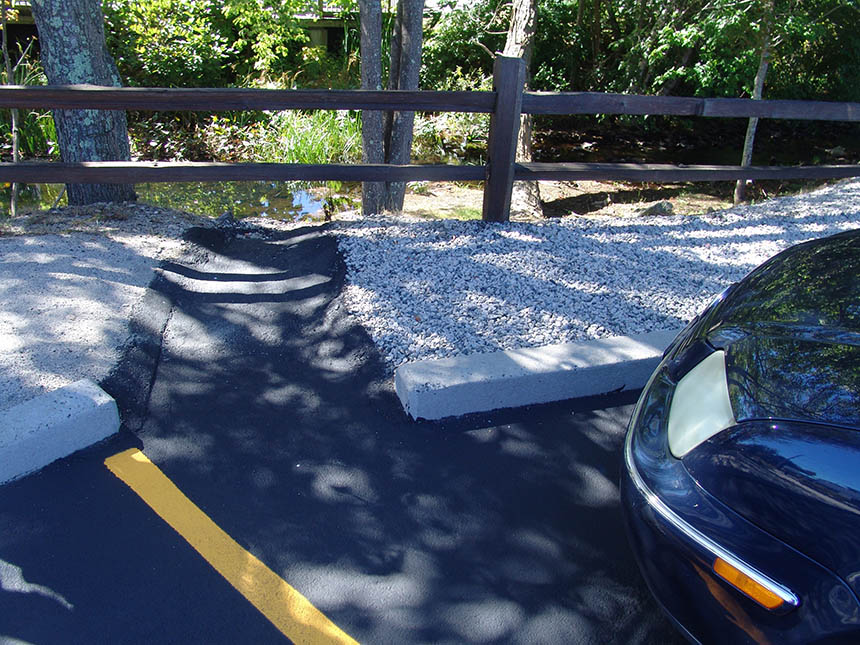 A supermarket parking lot in the village of Pascoag rushes stormwater directly into an unprotected wetland. This pollution-carrying runoff is negatively impacting the stream below. (Frank Carini/ecoRI News)