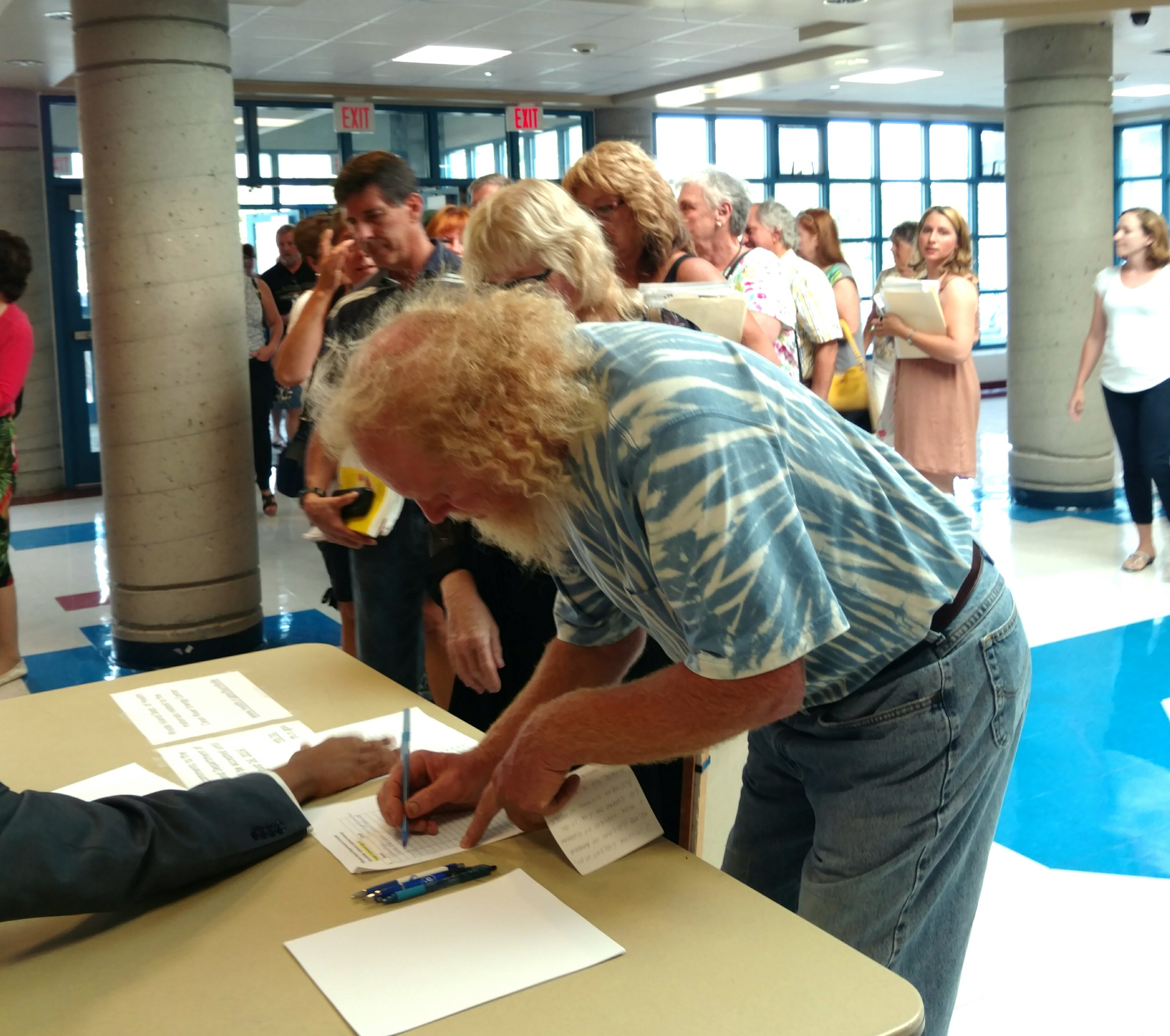 All 34 speakers at an Aug. 9 public hearing spoke against the proposed fossil-fuel power plant. The public signed up outside the Burrillville High School auditorium to make statements. (Tim Faulkner/ecoRI News)