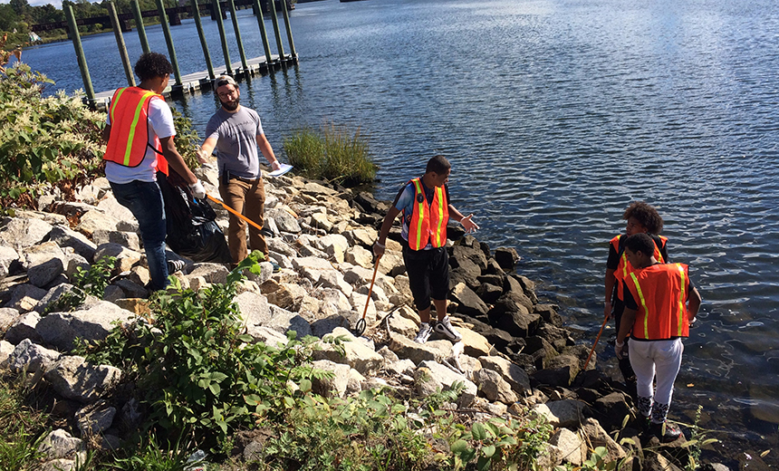 Teacher Rob McKinley helps A-Venture Academy students clean up trash along the Seekonk River. (Todd Corayer/ecoRI News photos)