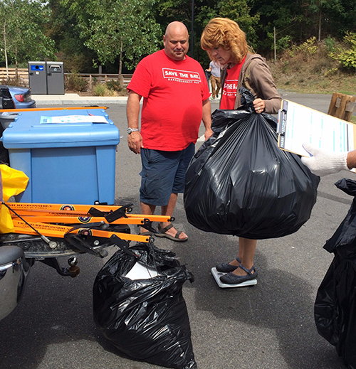 Dave Henault and Bonnie Combs weigh trash collected at Festival Pier in Pawtucket.