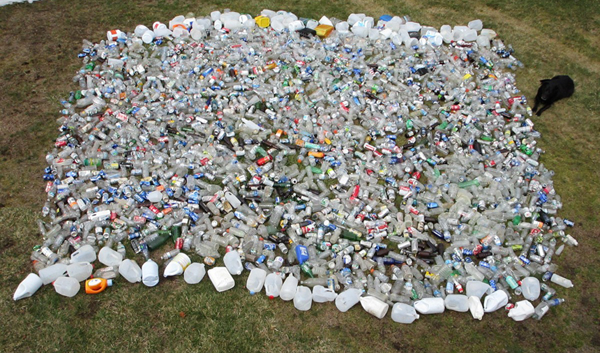 Little Compton, R.I., resident Geoff Dennis, with help from his black lab Koda, relaxing to the right, picked up nearly 2,400 plastic bottles from local beaches last year. (Courtesy photo)