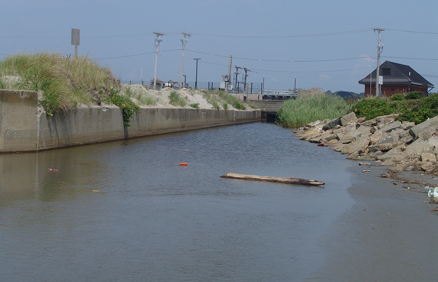 The stream that runs into Easton’s Beach in Newport, R.I., from a moat across Memorial Boulevard, often contains bacteria, especially after heavy rains, that can close the popular beach to swimming. A UV treatment system installed several years ago has helped reduce closures. (ecoRI News)