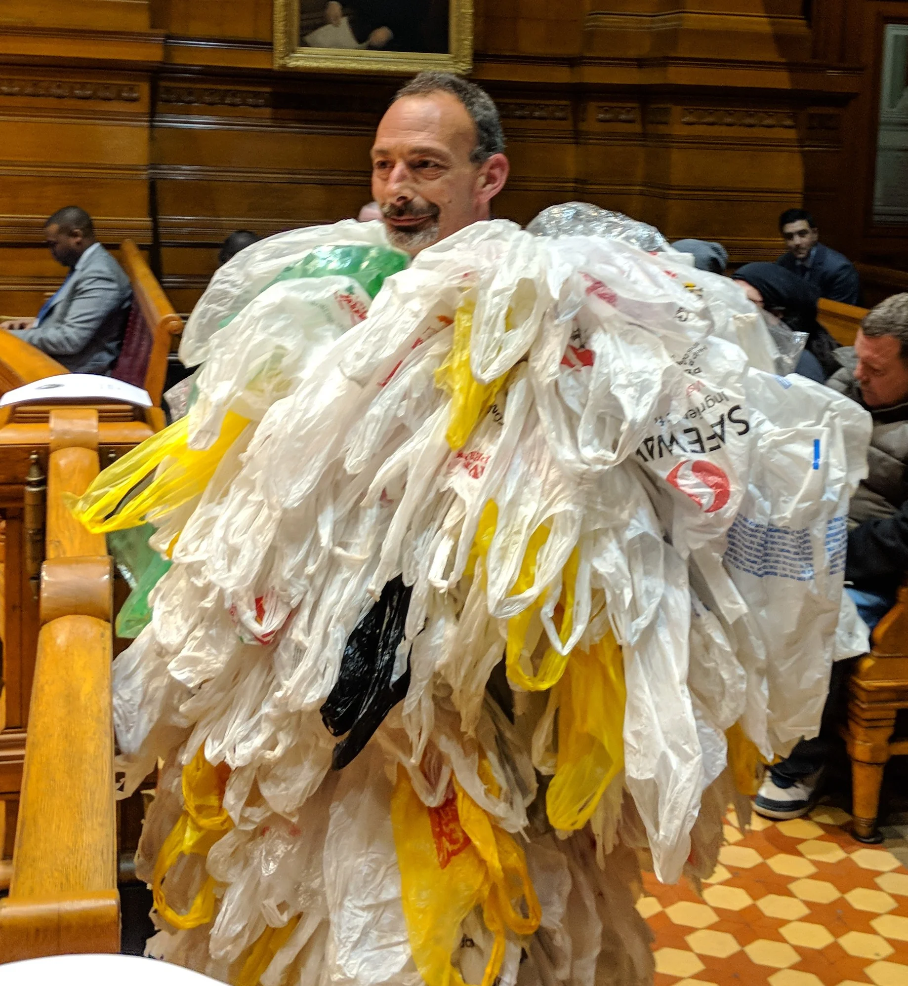 At the Providence City Council's March 1 meeting, Lou Perrotti, director of conservation programs at Roger Williams Park Zoo, wore a suit of plastic bags in support of the ban. (Tim Faulkner/ecoRI News)