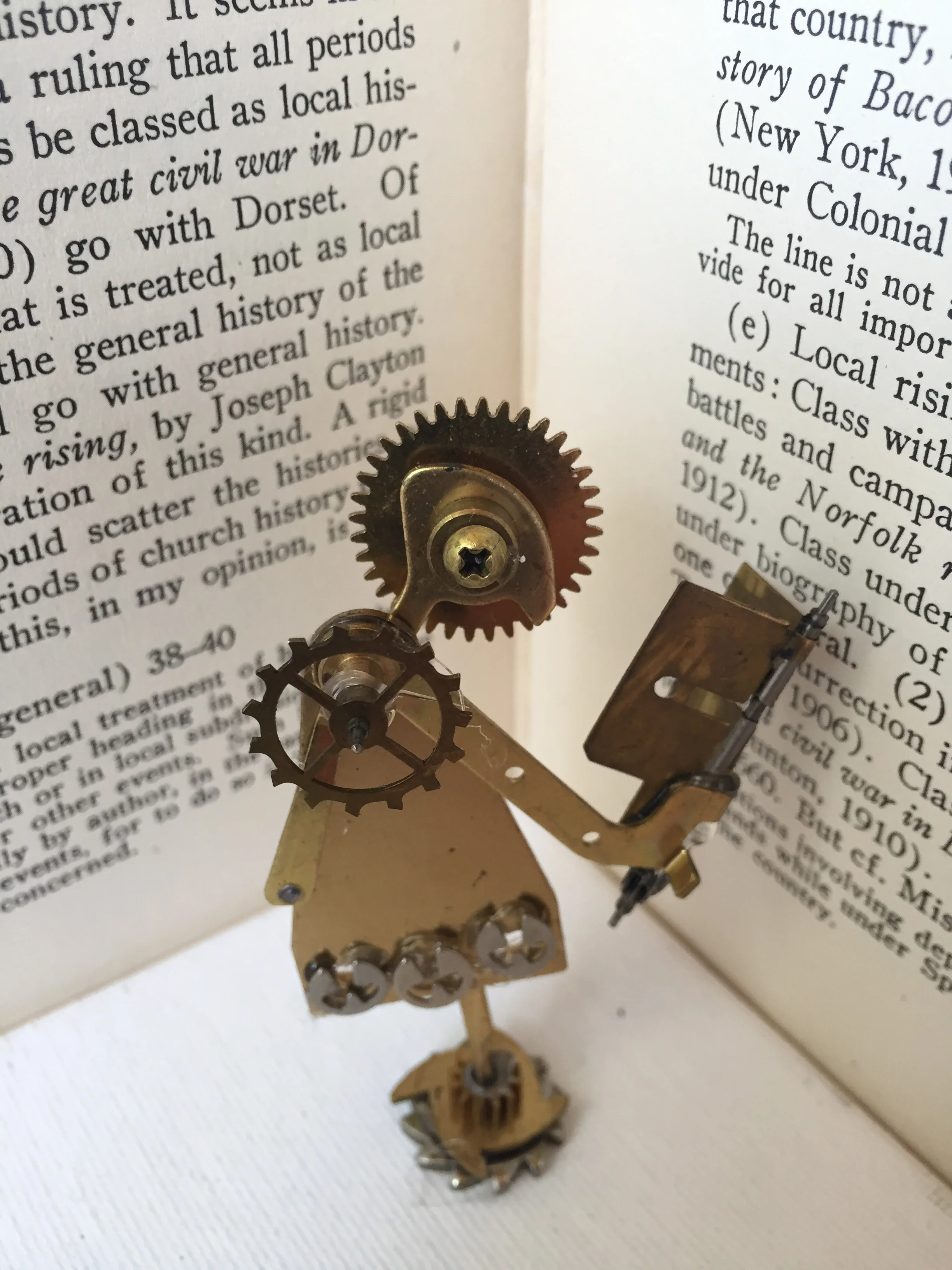 "The Reader." (4" x 2") Metal clockworks and adhesive. (2017) by Melody Weintraub