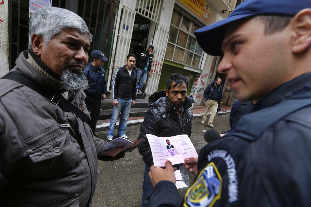 Greek police check the papers of refugees.