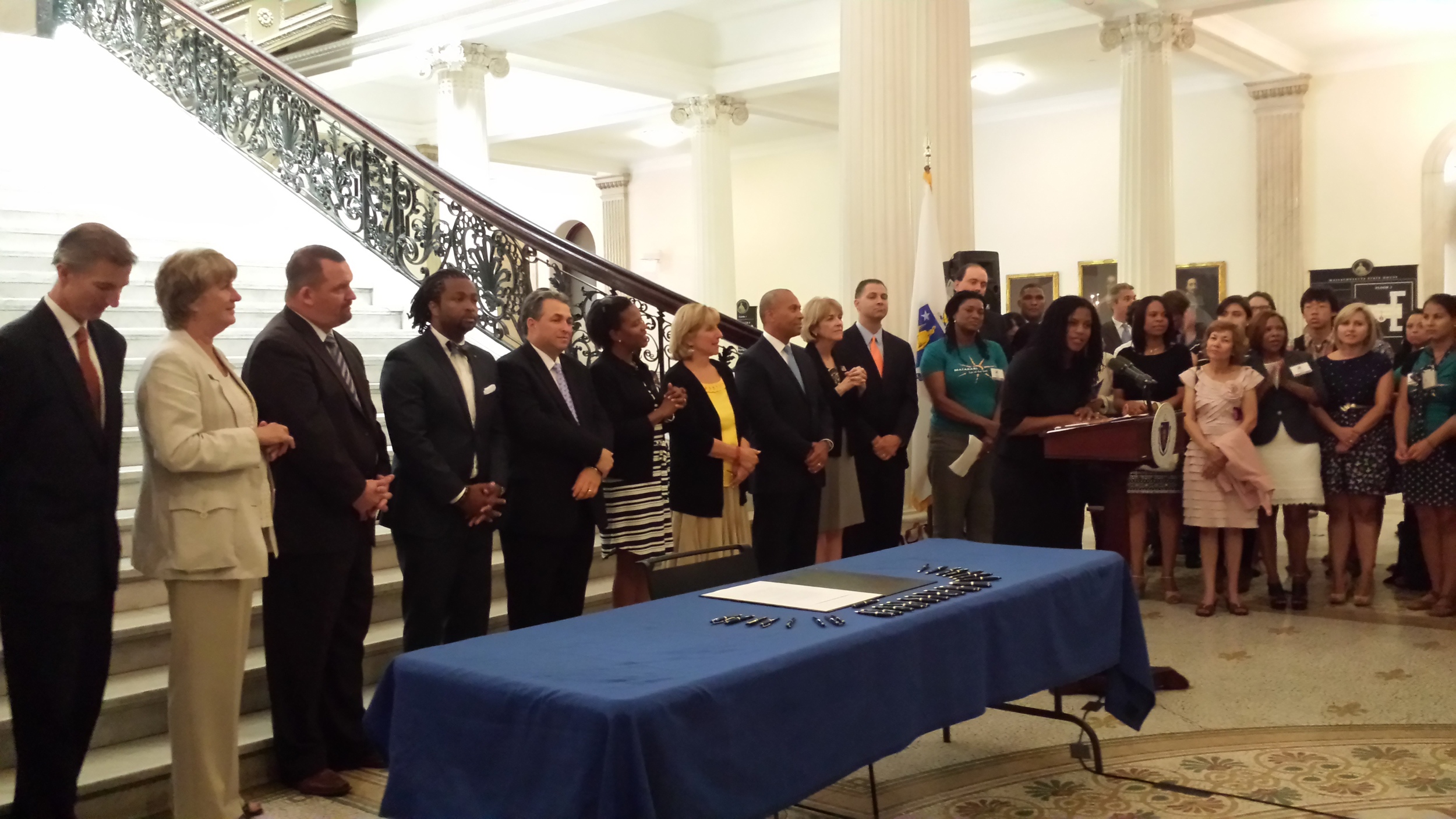 Lydia Edwards (speaking) and other coalition members at the signing of the Domestic Workers Bill of Rights (Governor Patrick to Lydia's right)