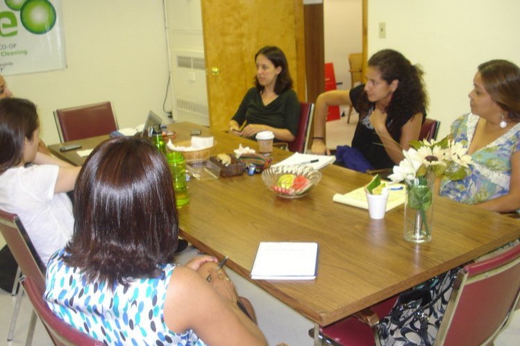  Six women sitting around a table. 