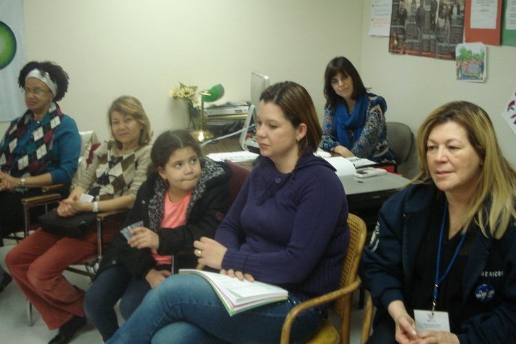  Five women and one girl sitting in chairs facing forward. One woman wears a lanyard. 