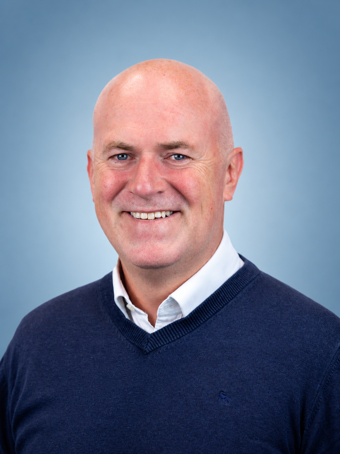 Smiling Bald Executive Headshot.png