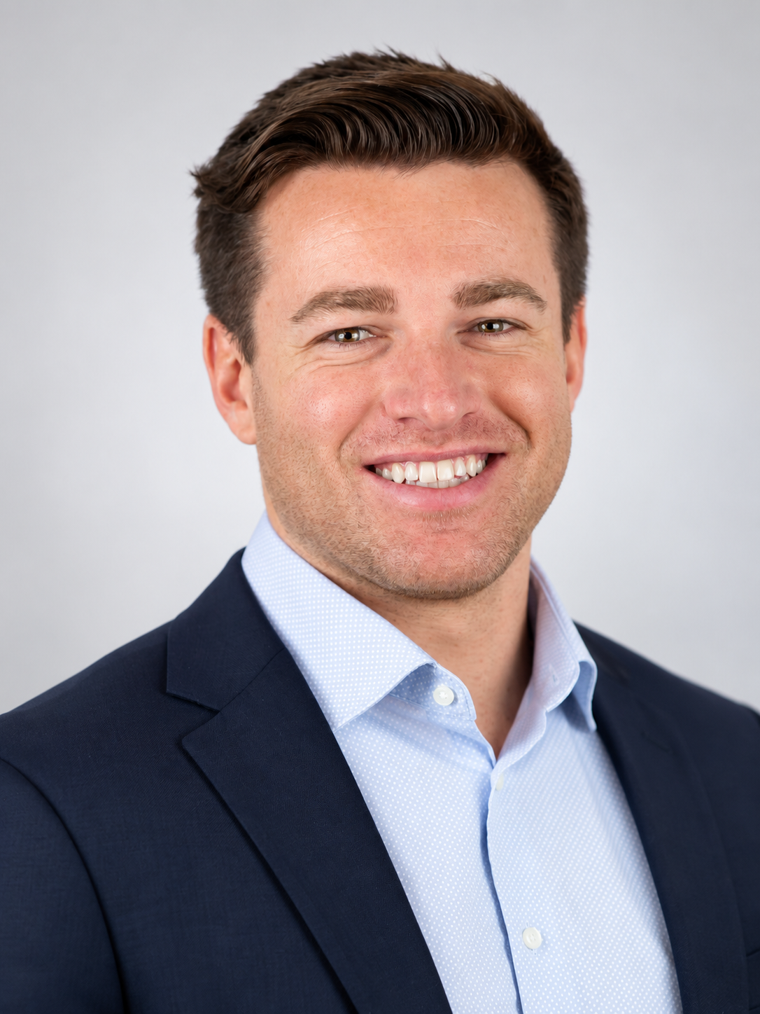 Warm Corporate Headshot in Navy Suit.png