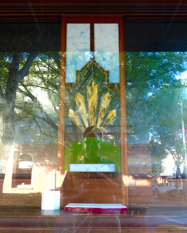 My reflection from a store window in oroville, california angled to appear as if I wear the stained glass feathered headress, which has five feathers for the five core beliefs.
