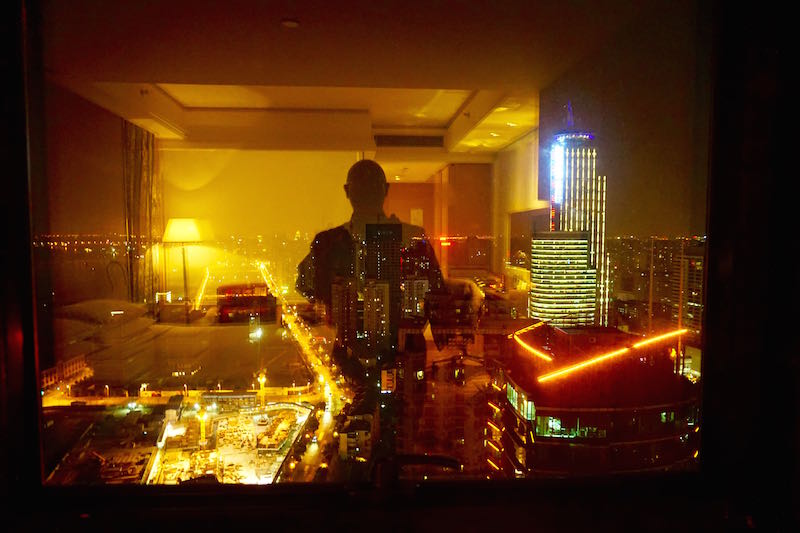 Same view from my hotel room form the night before with my shadow self refelcted agaisnt the Shanghai night.