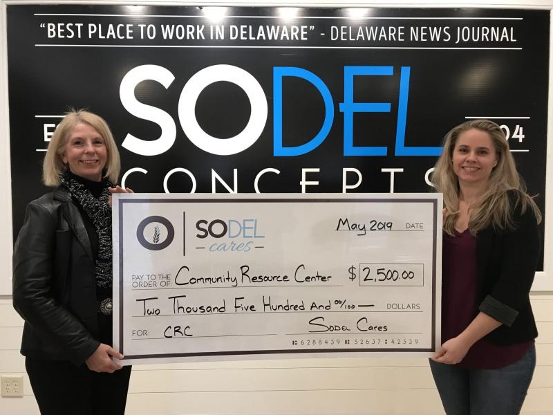 Community Resource Center Director Jo Allegro-Smith, left, accepts the $2,500 donation check from Lindsey Barry, SoDel Concepts controller. SUBMITTED PHOTO
