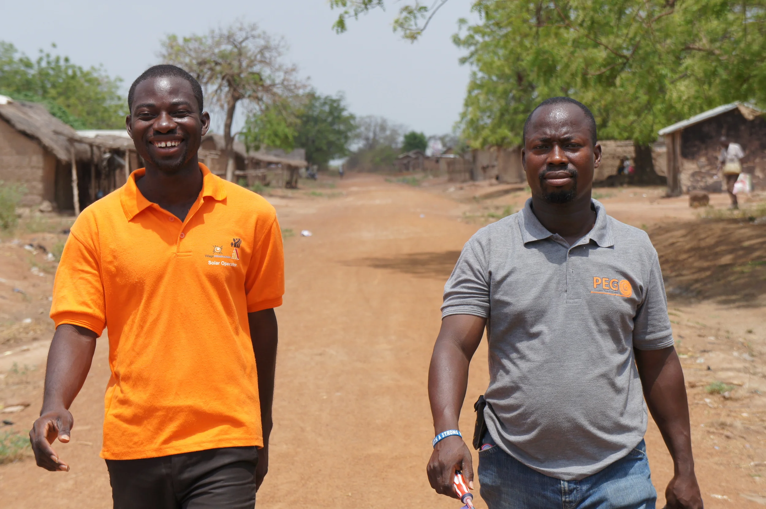 PEG employees on dusty village road.JPG