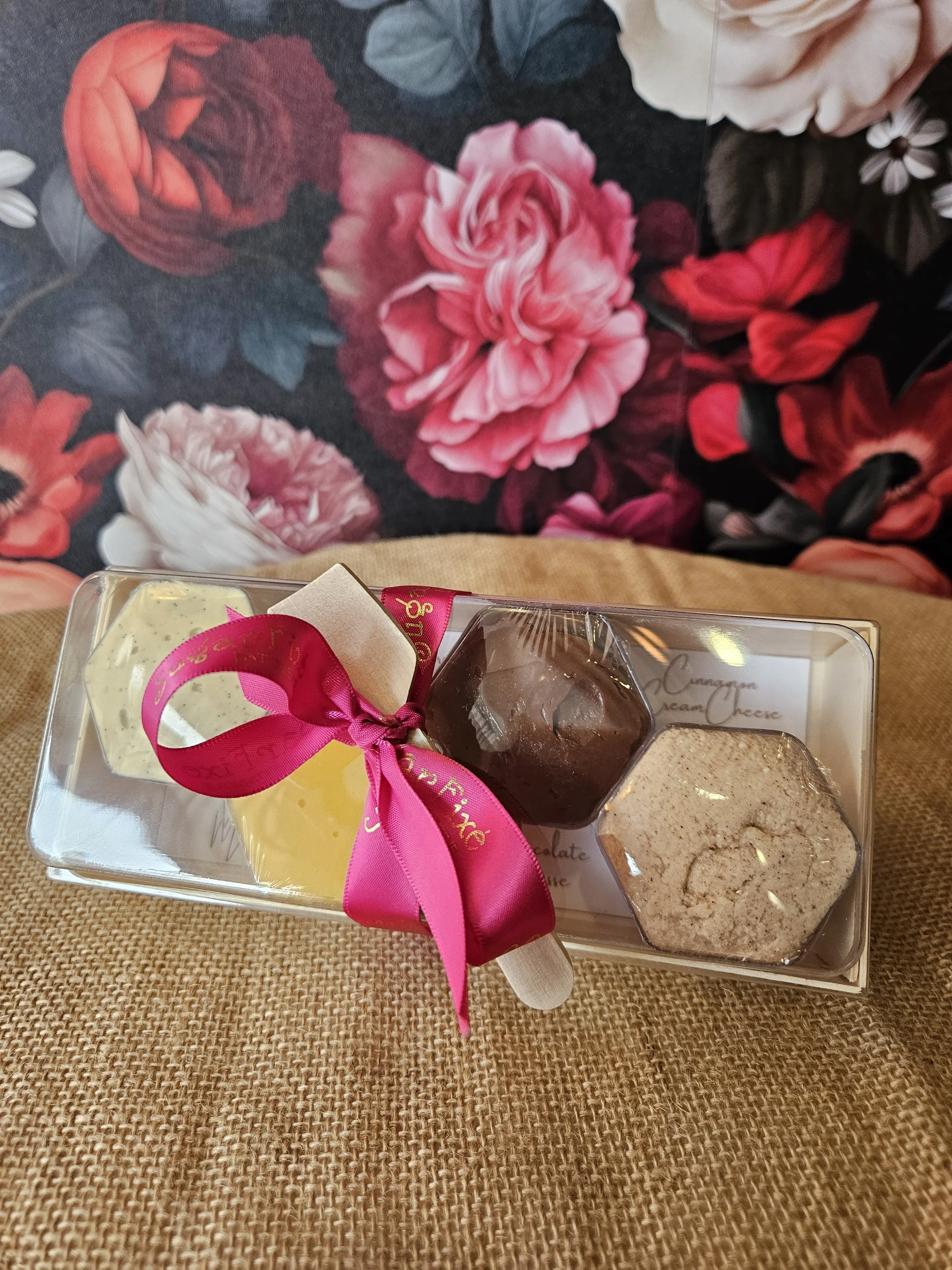 Clear tray of assorted cake tasting slices tied with a pink ribbon
