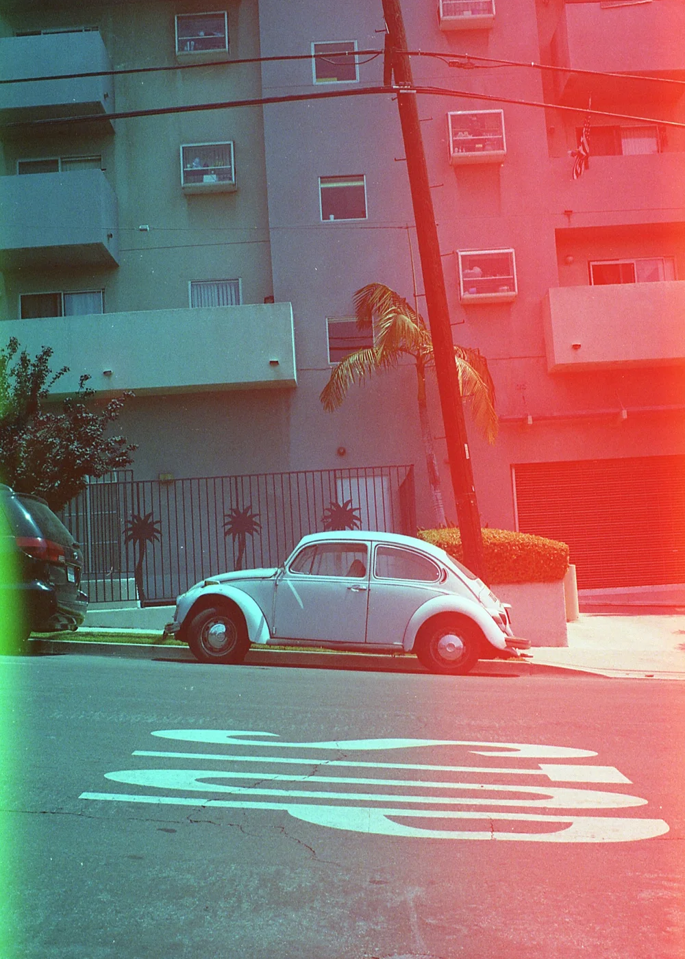 A car in front of a building shot on Psych Blues 2, an experimental film stock