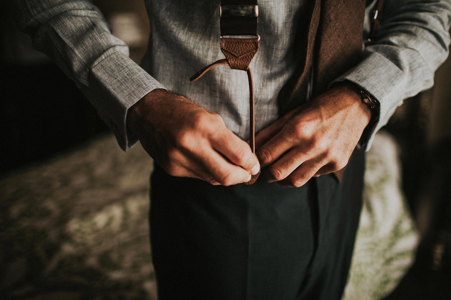  groom tying braces 