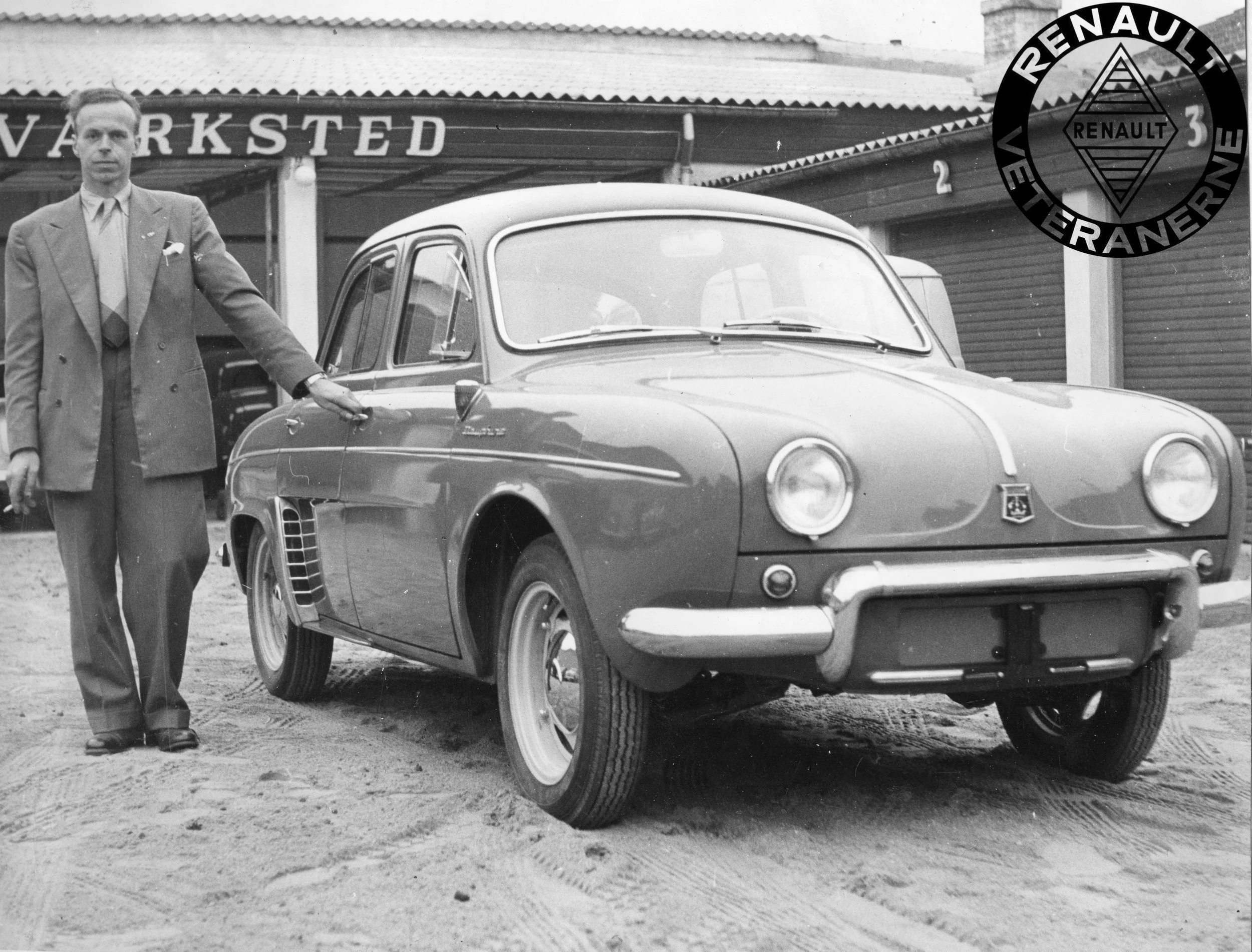 Alwyn Haugaard blev Renault-forhandler i Randers i foråret 1956 – netop som Dauphine blev lanceret. Den nye forhandler ses her med en af de allertidligste Dauphiner i Kronjylland. Bemærk, at bilen har stjernefælge ligesom 4CV, og de store sideblinklygter på forskærmen.