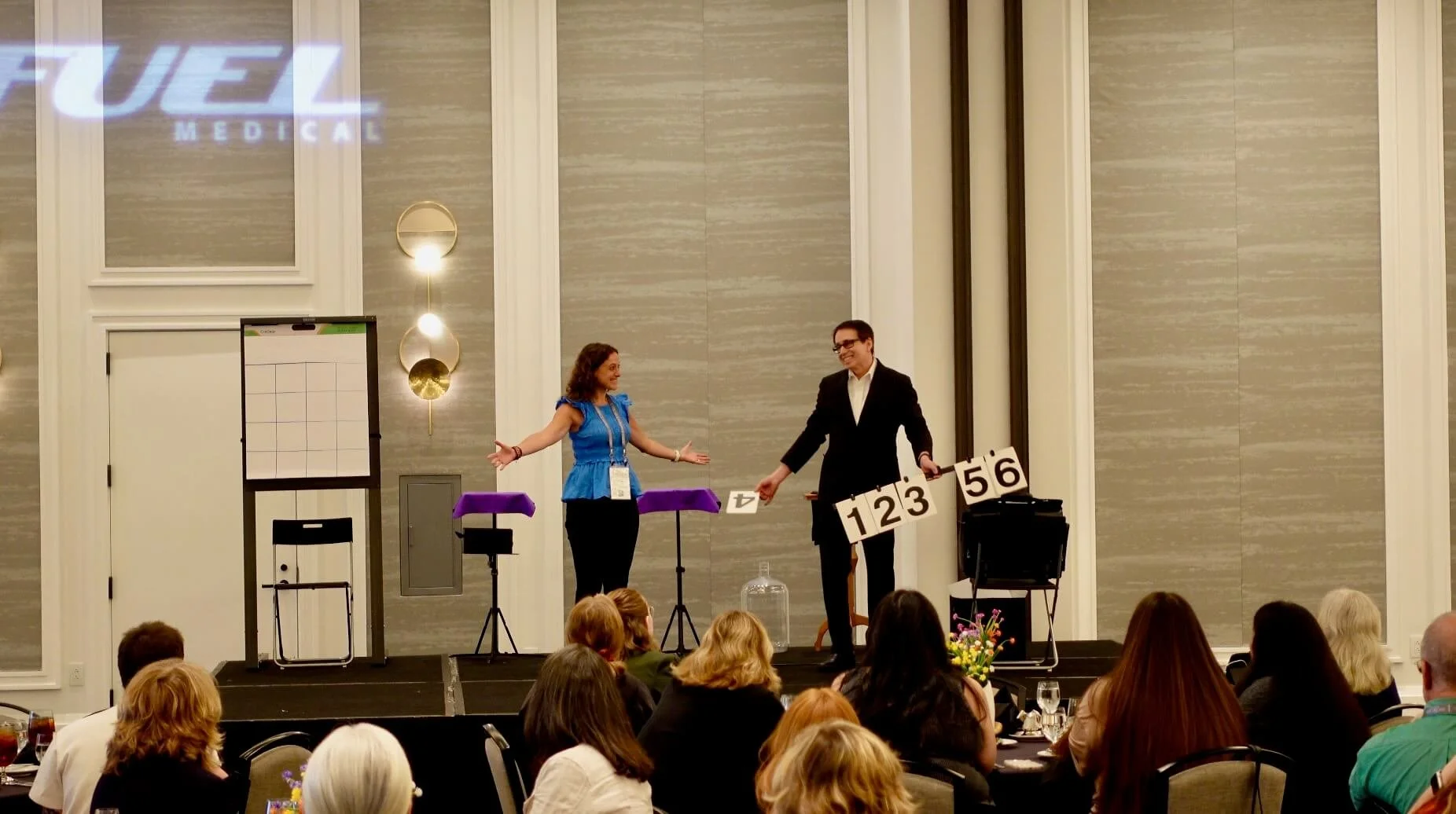 Corporate mentalist Lou Serrano interacts with audience volunteer on stage