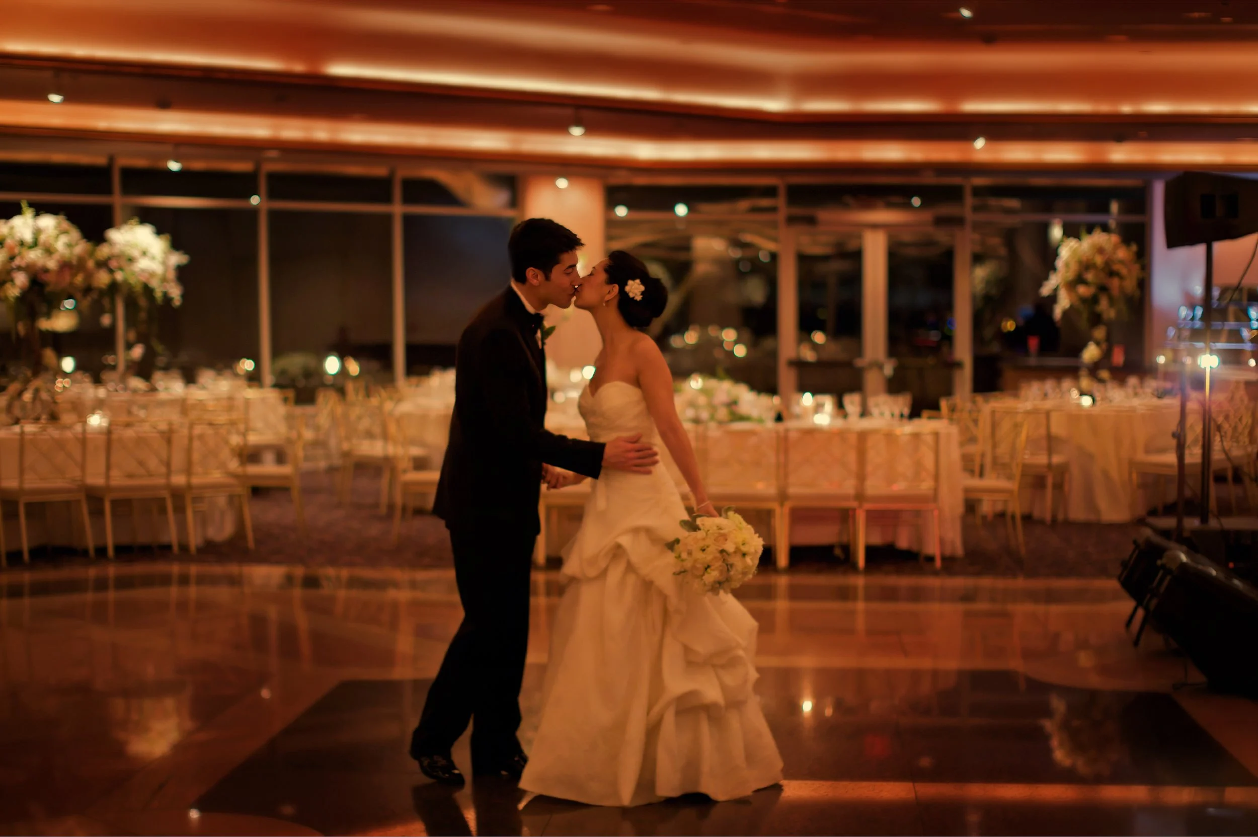 Bride and groom kiss on the dance floor after their ballroom reveal at Glen Island Harbour Club