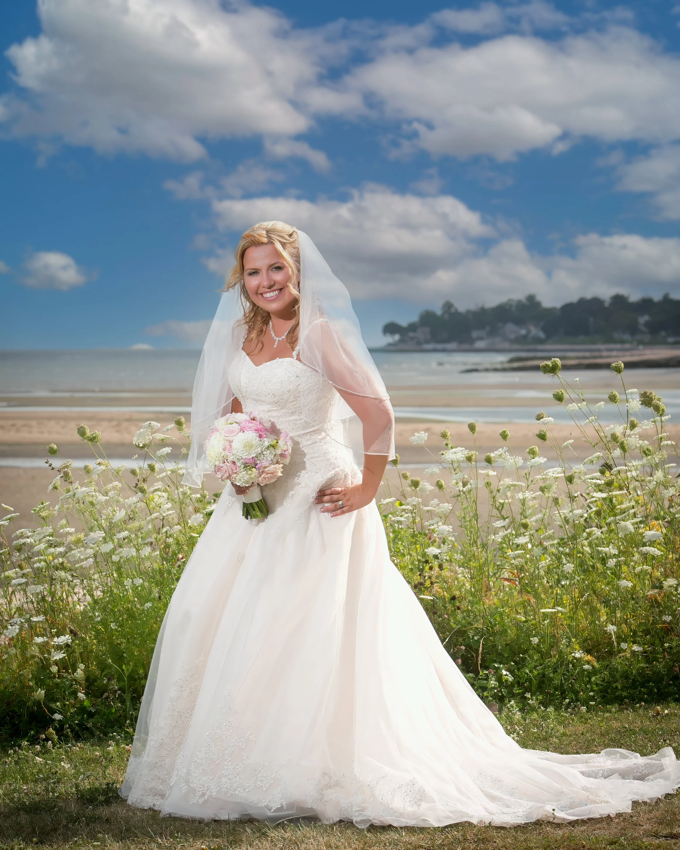Bridal portrait with seasonal flowers on Connecticut shoreline near Amarante’s Sea Cliff