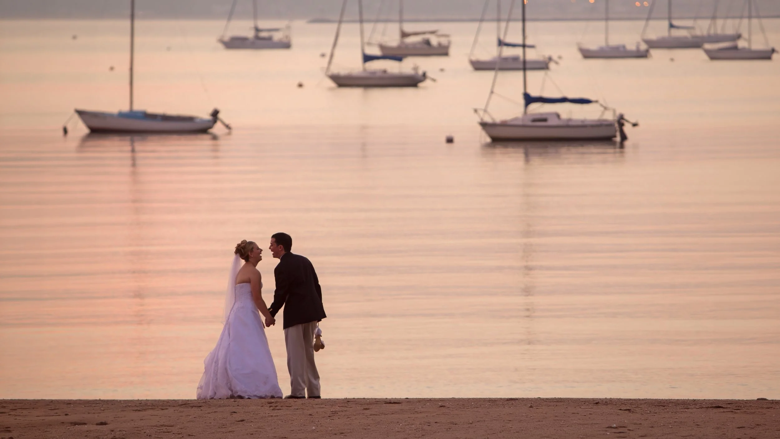 Bride and groom overlooking sailboats in New Haven Harbor at Anthony’s Ocean View wedding venue.