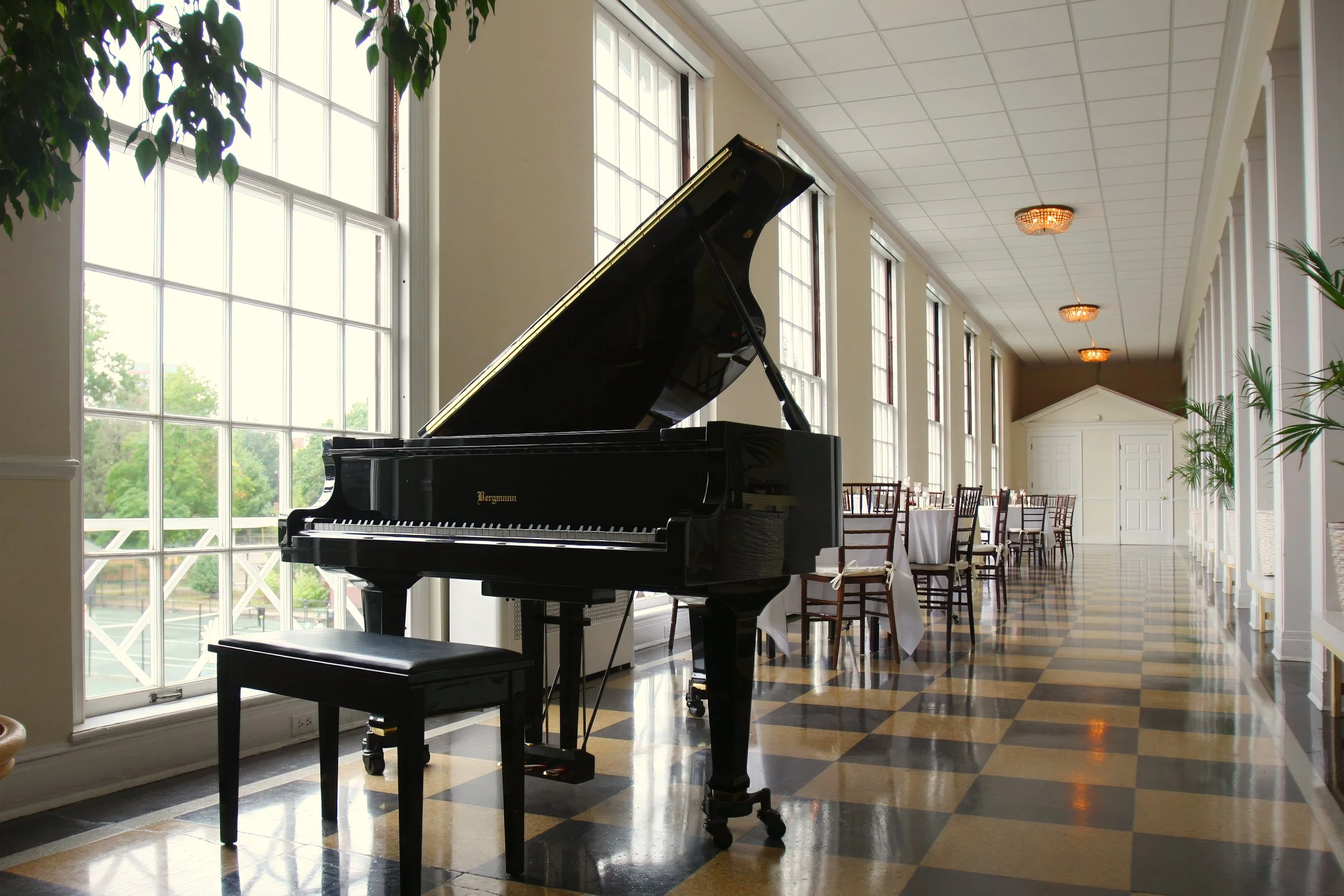 Elegant hallway with grand piano set for cocktail hour at the New Haven Lawn Club wedding.