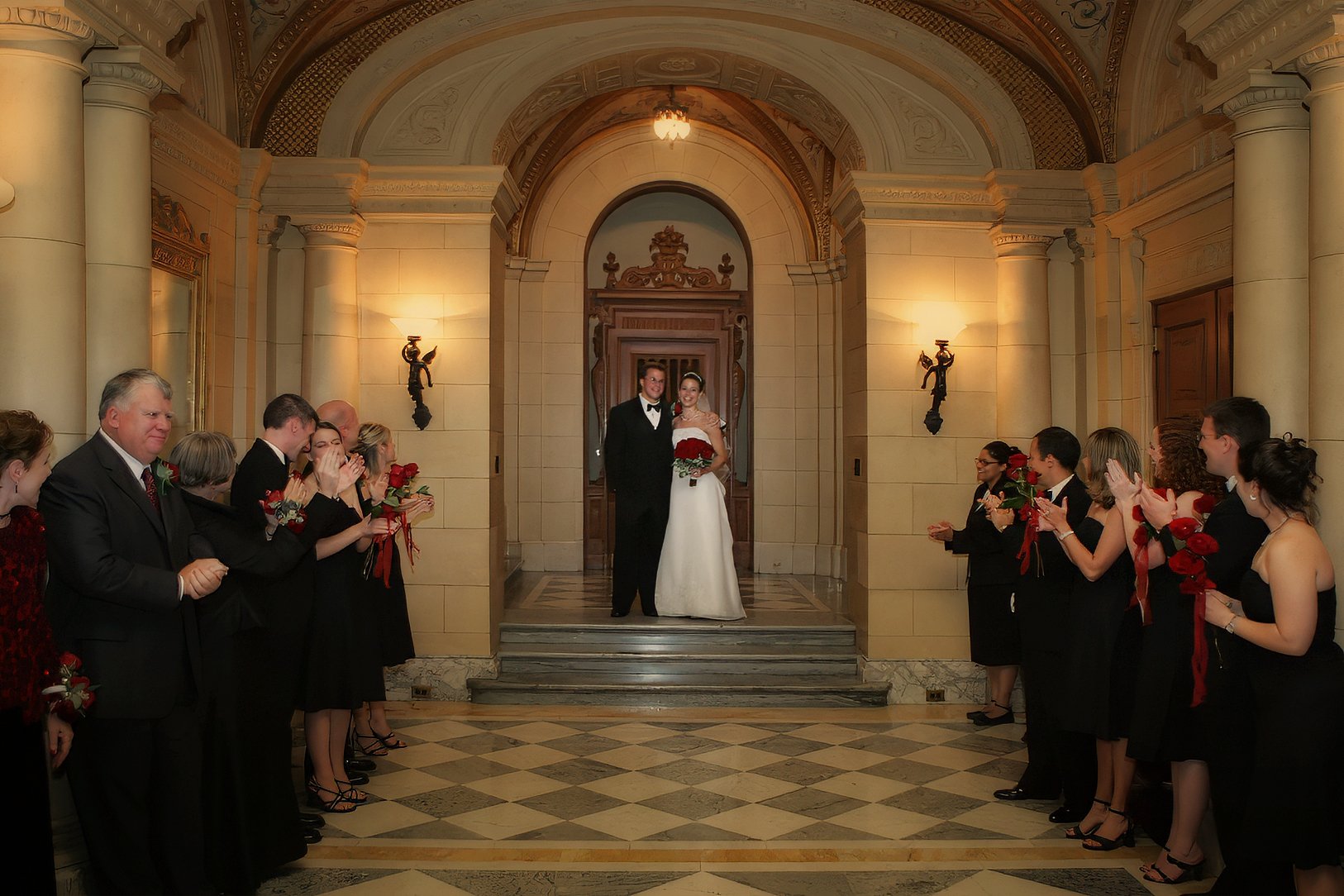 Bride and groom making their grand reception entrance as family and bridal party cheer.