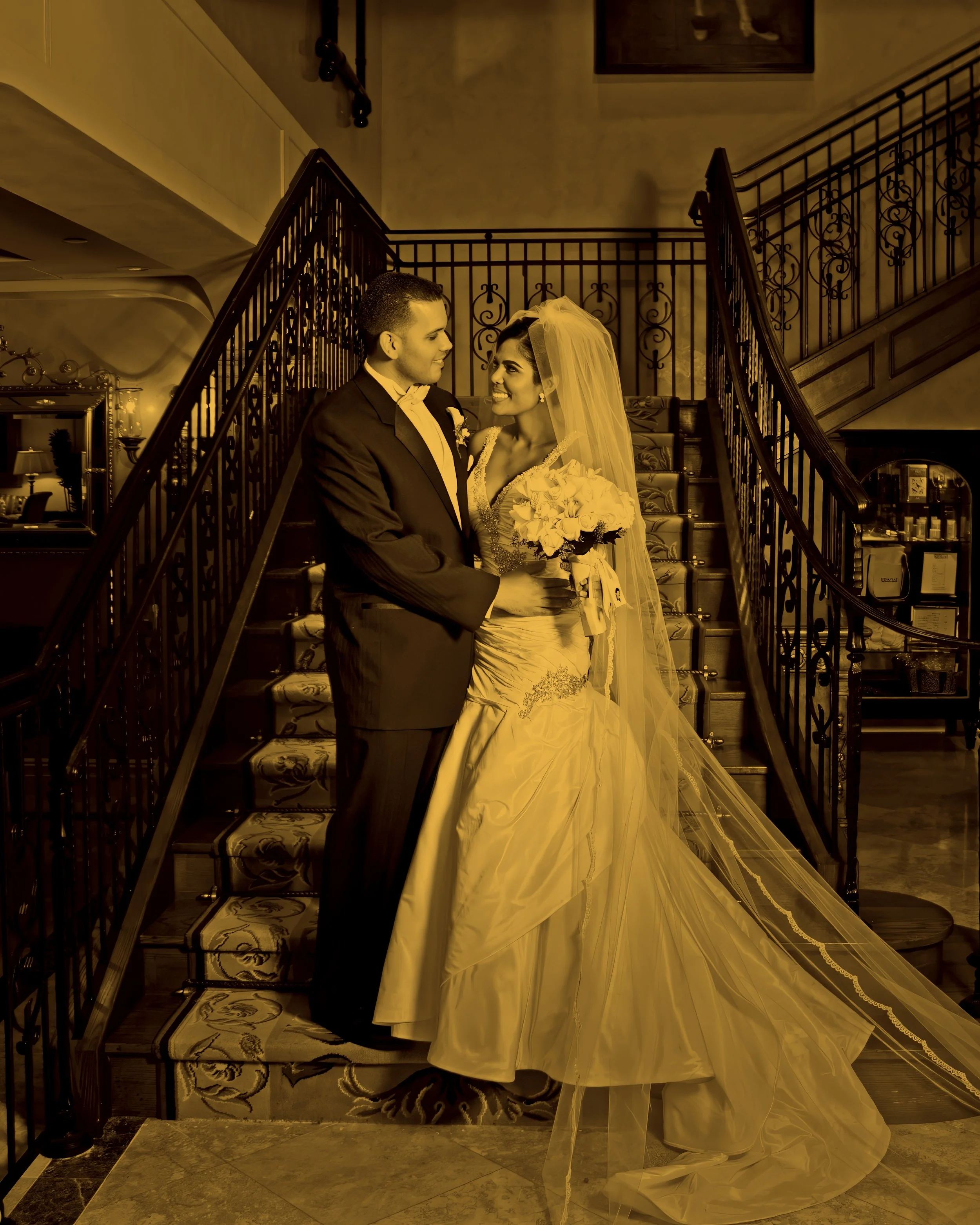 Fine art full length portrait of bride and groom on the grand staircase at Delamar Greenwich Harbor wedding venue in Greenwich, Connecticut.