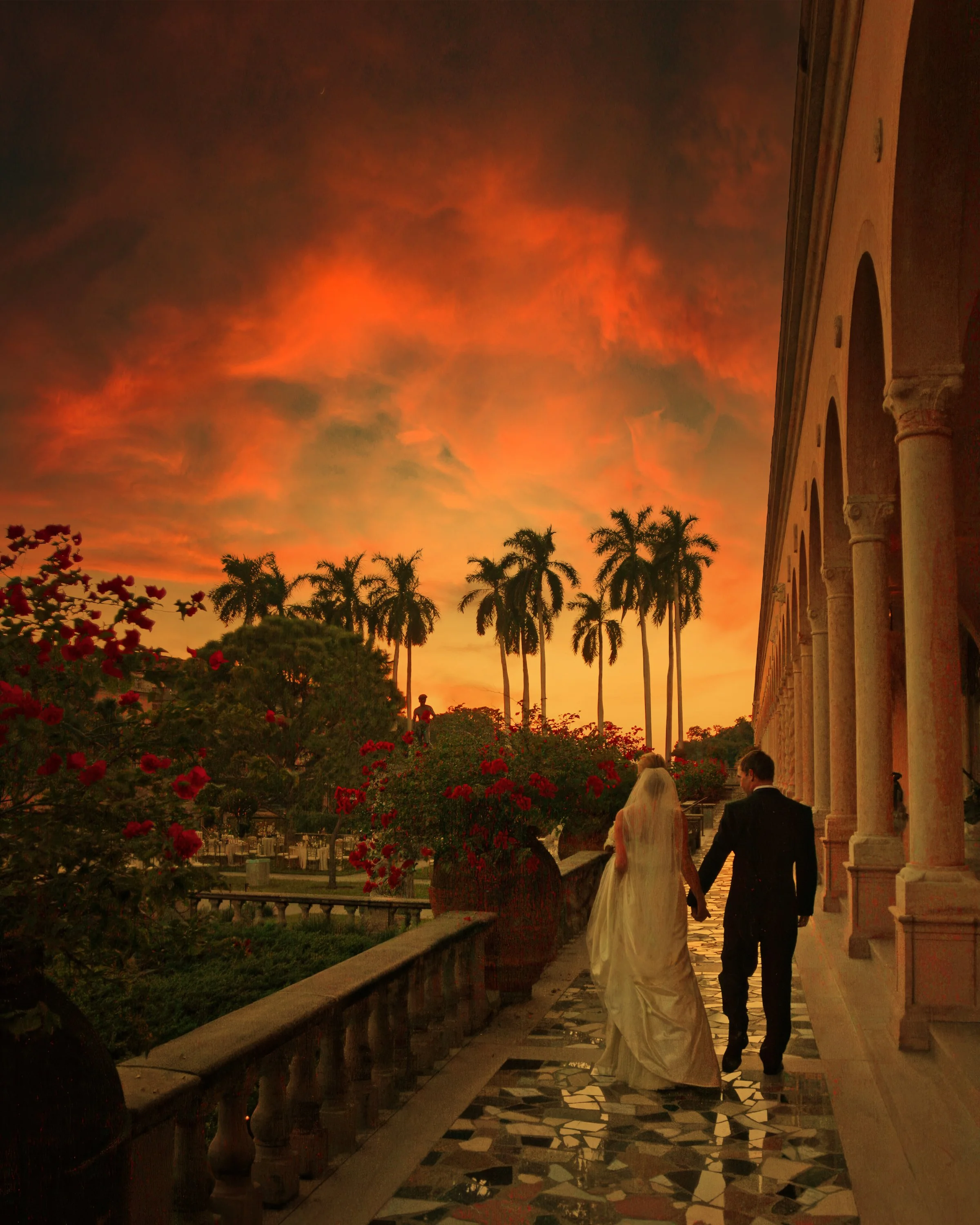Bride and groom walking along a garden path beside the museum arcades at the Ringling Museum in Sarasota