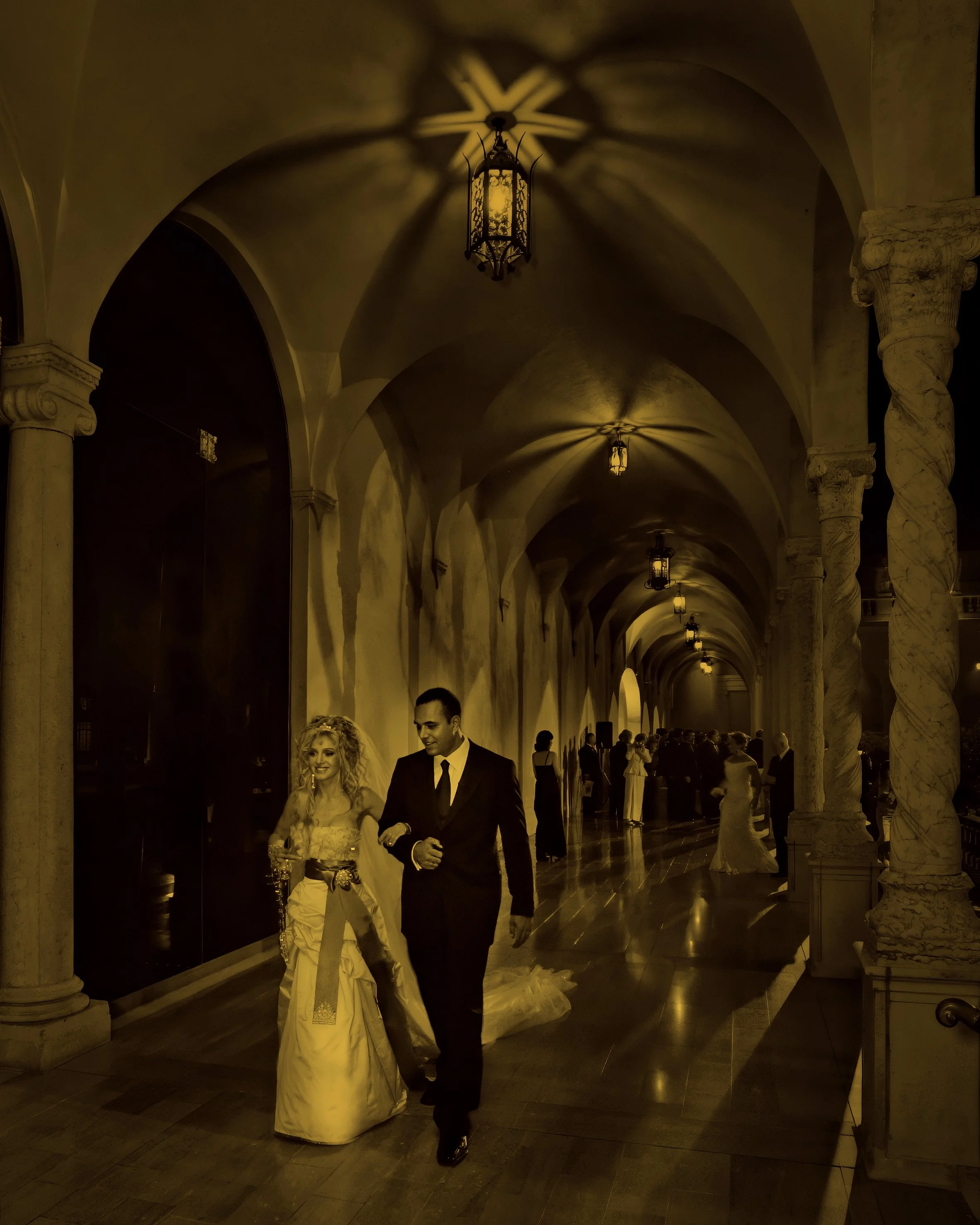 Bride and groom walking beneath the historic arcades at the Ringling Museum in Sarasota