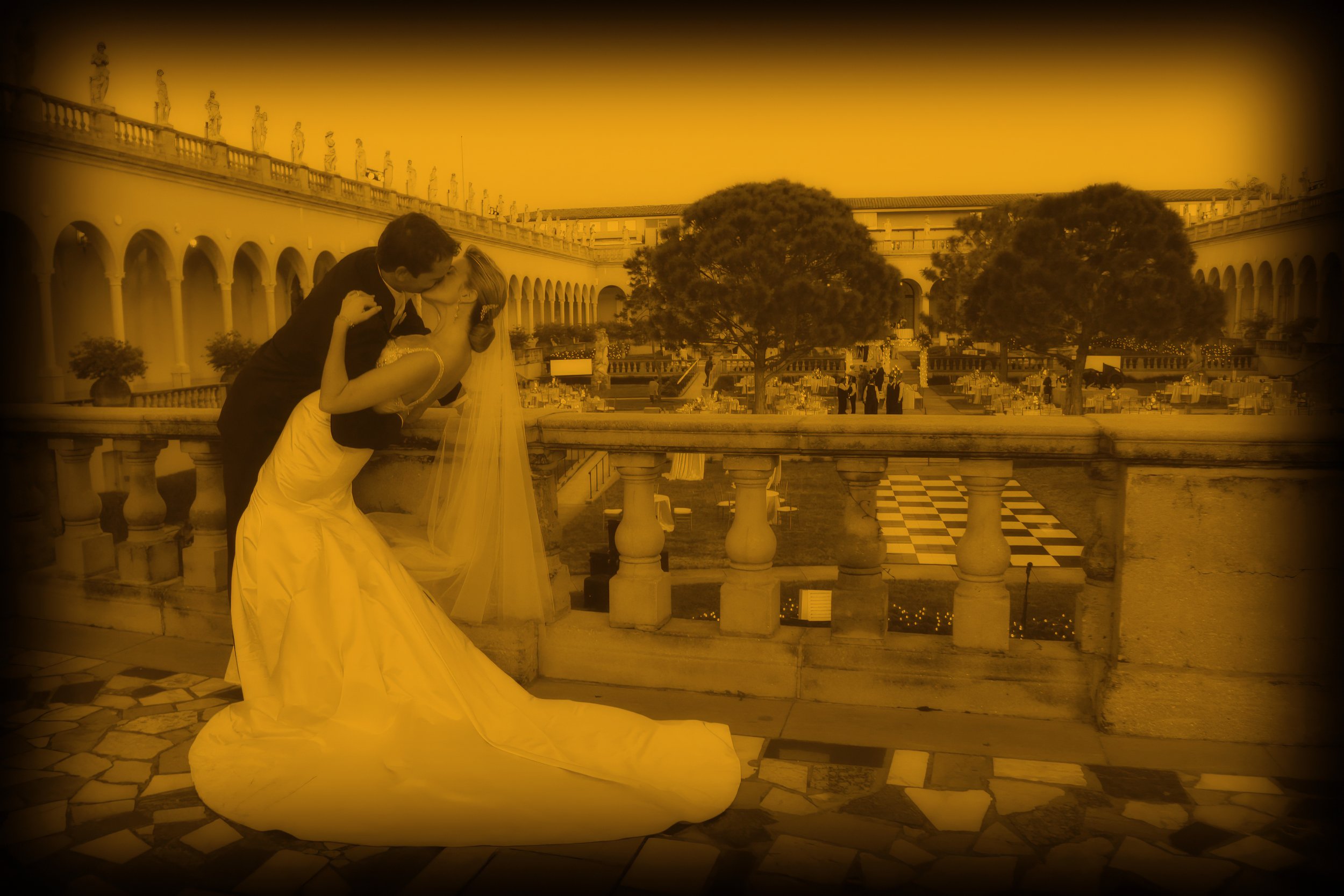 Bride and groom share a romantic kiss above the Ringling Museum courtyard