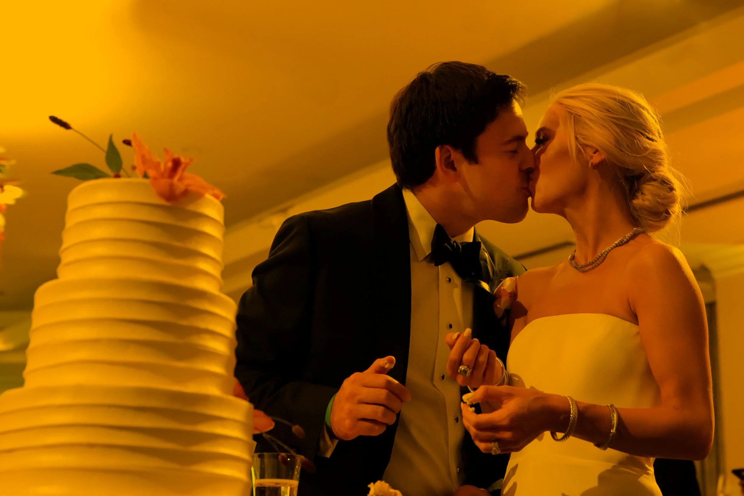 Bride and Groom Kiss After Cutting Wedding Cake