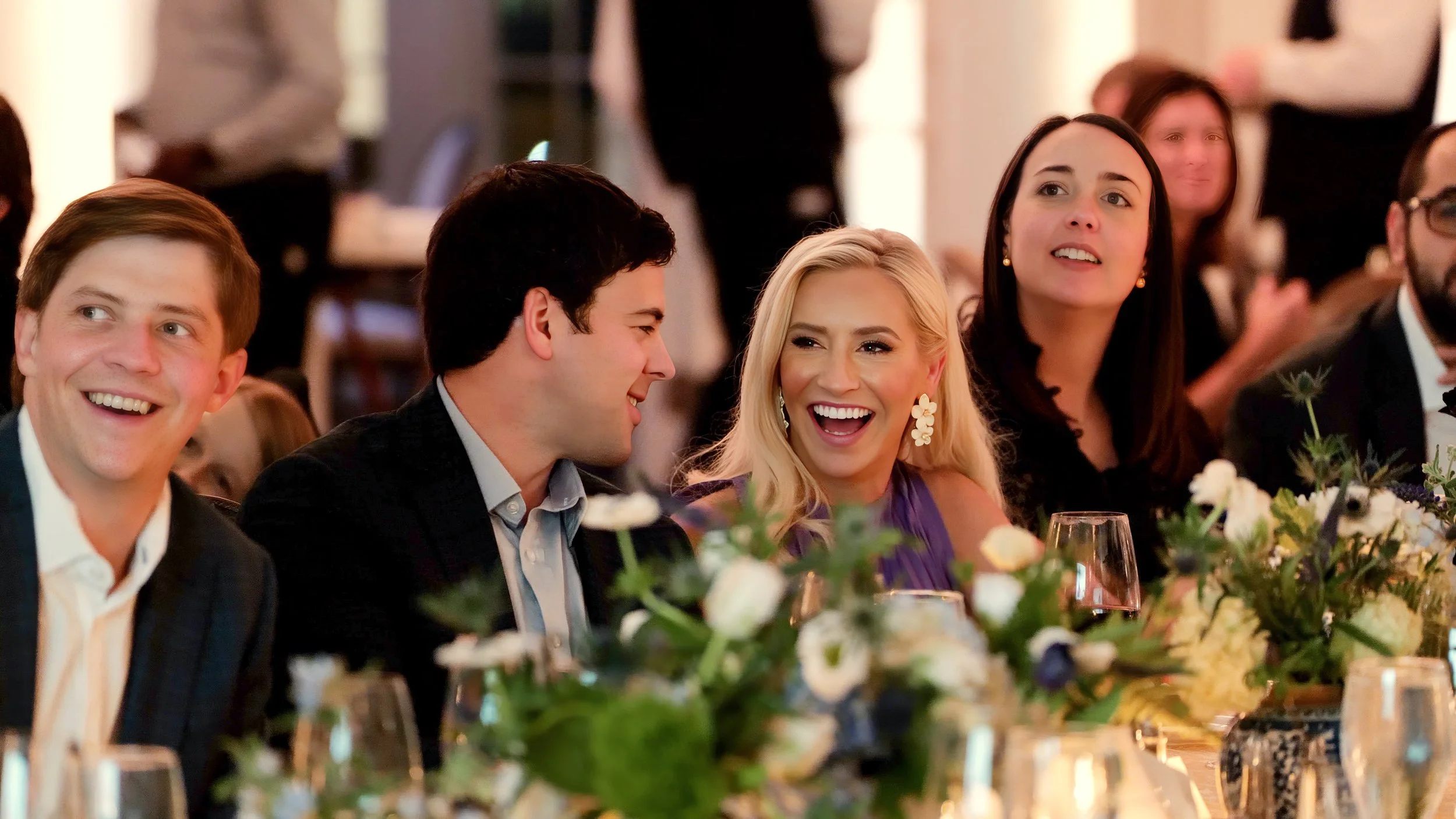 Bride and groom laugh as they listen to toasts during their welcome dinner in the Donald Ross Room at Pinehurst Resort.