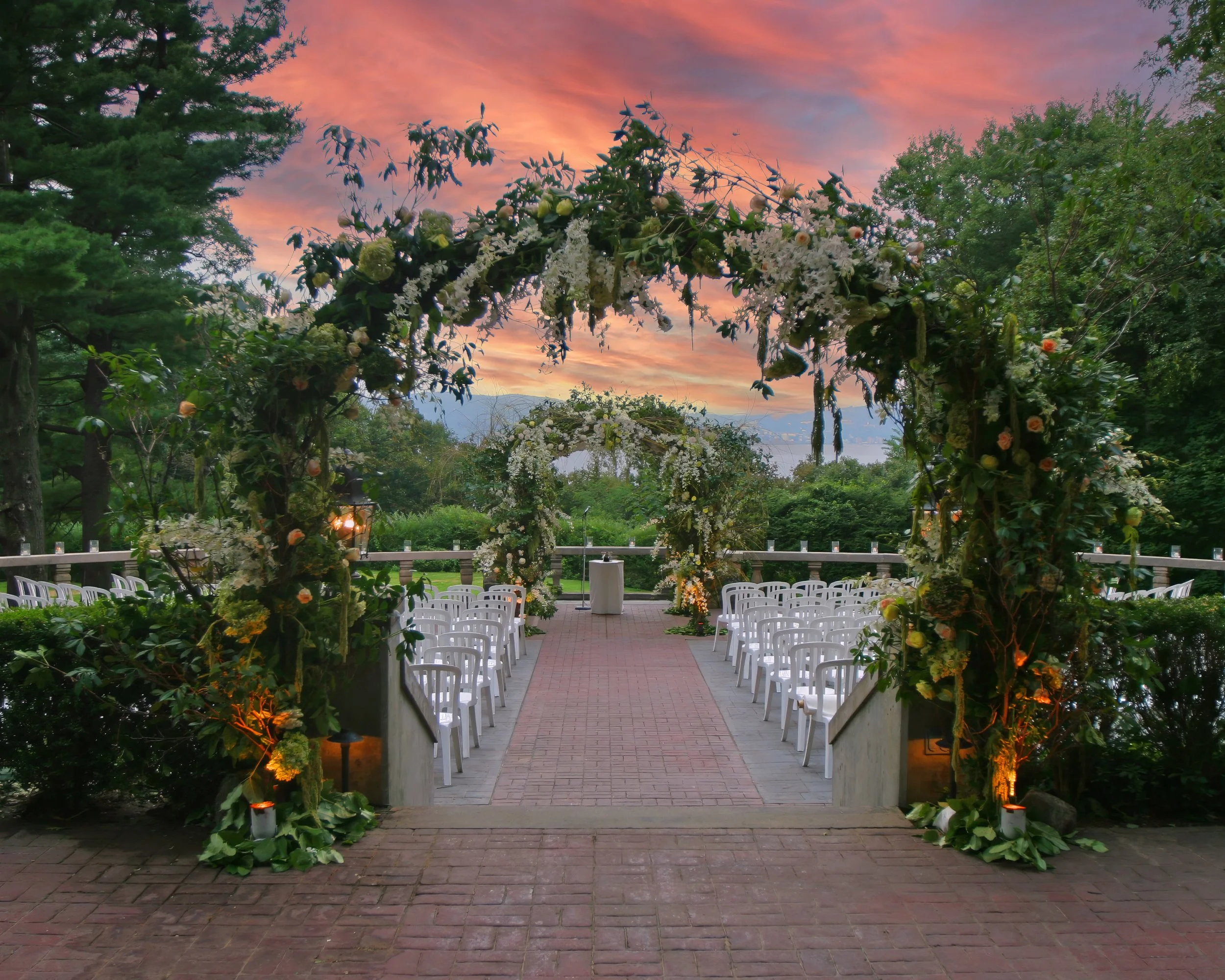 Extravagant wedding floral arrangements and a Chuppah set for a ceremony on the Tappan Hill Terrace overlooking the Hudson Valley.