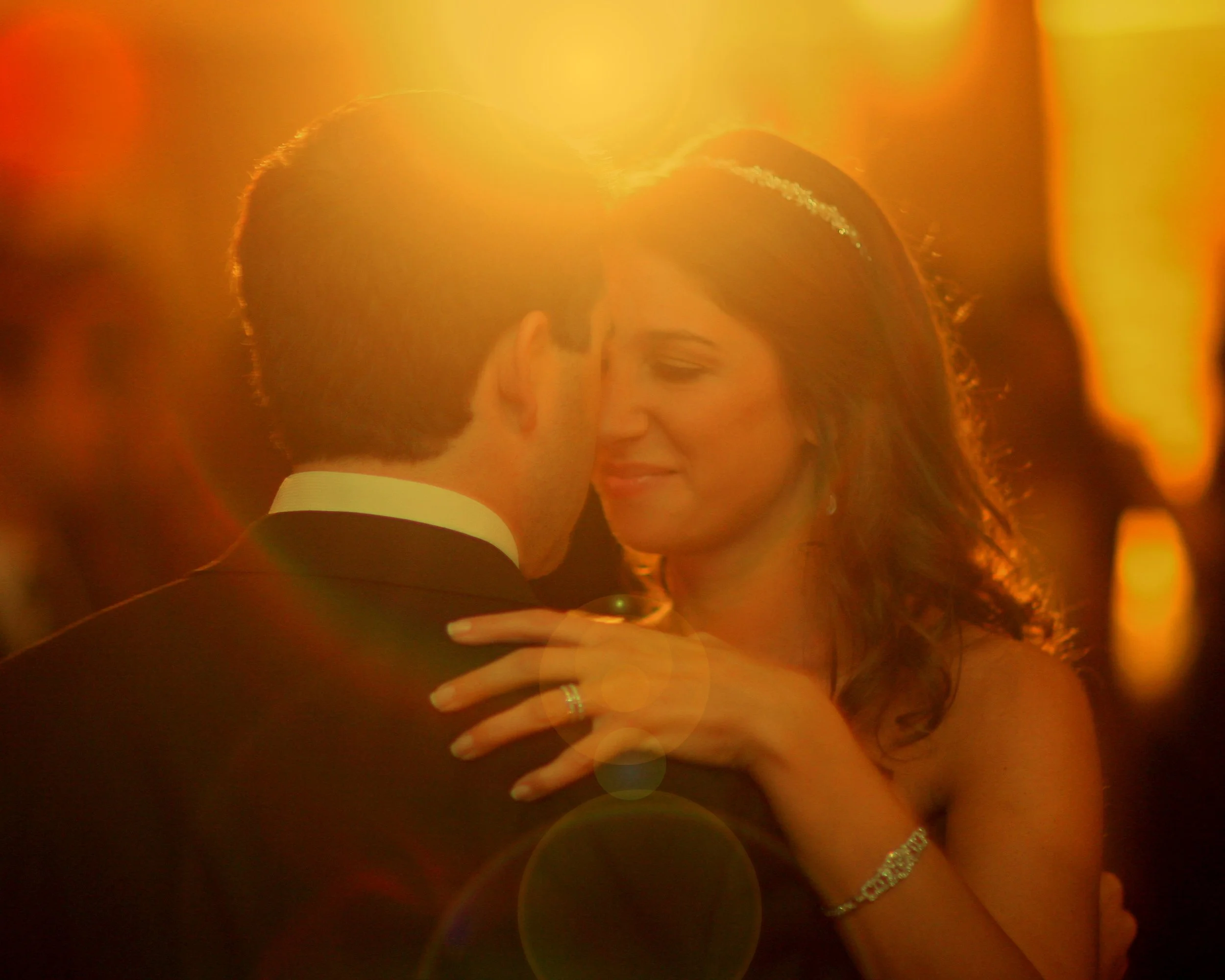 Romantic first dance in the Tappan Hill Ballroom captured with lens flare, showing hearts aglow around the bride and groom.