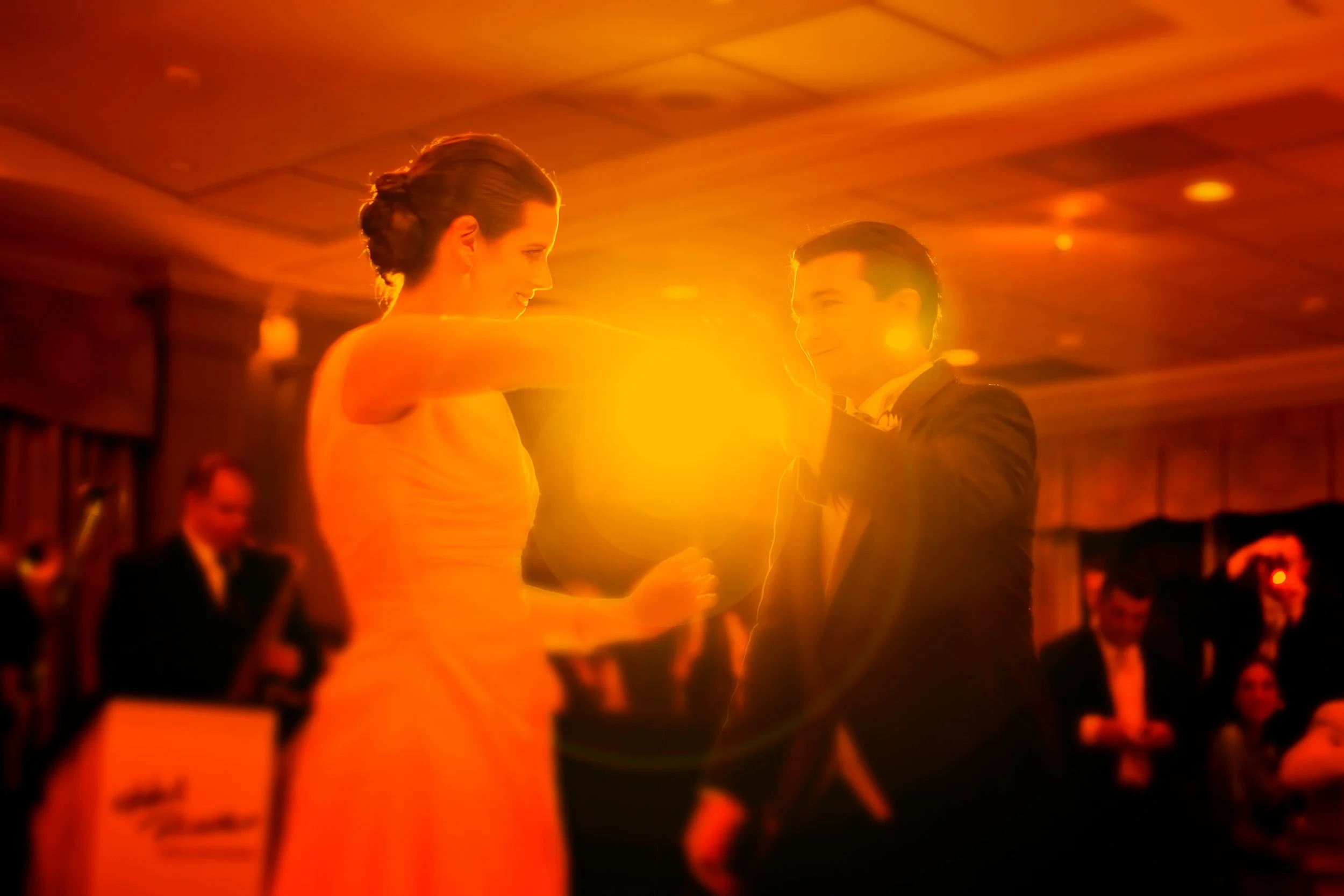 Fine art split-toned photograph of a bride and groom’s first dance at Tappan Hill with creative light flare.