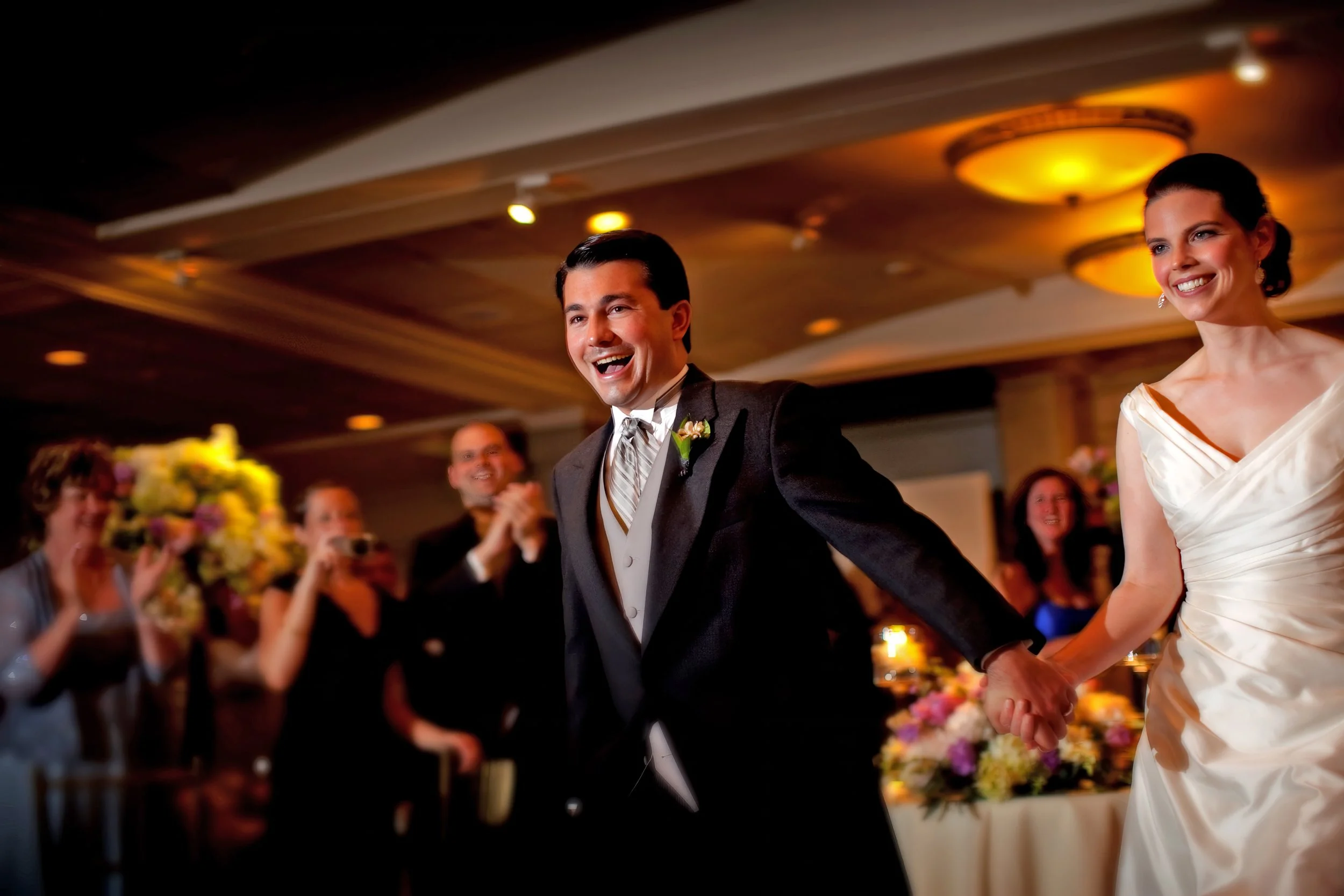 Bride and groom make a joyous grand entrance into the Tappan Hill Ballroom during their wedding reception.