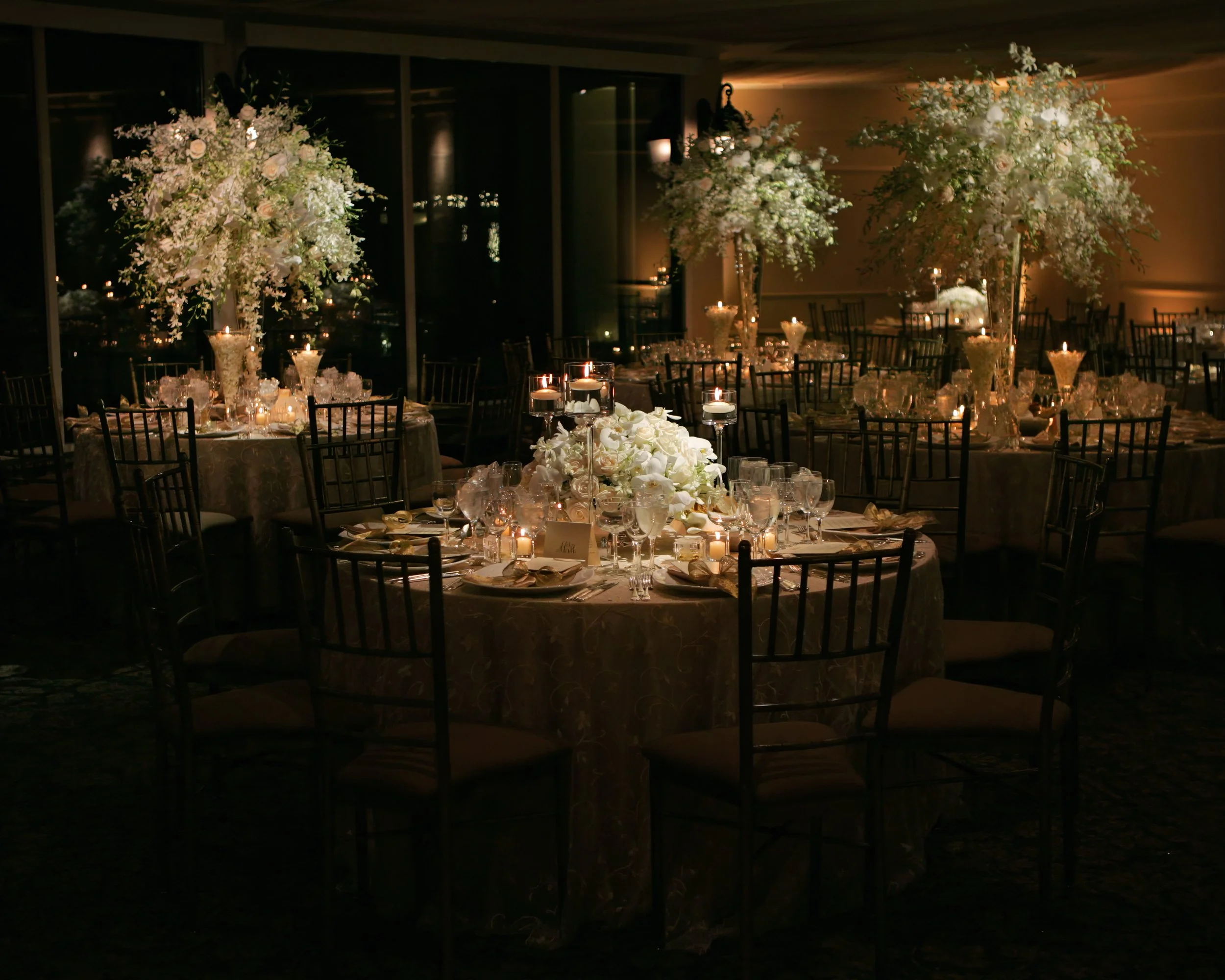 Lavish floral centerpieces decorate the Tappan Hill Ballroom set for a luxurious wedding reception.
