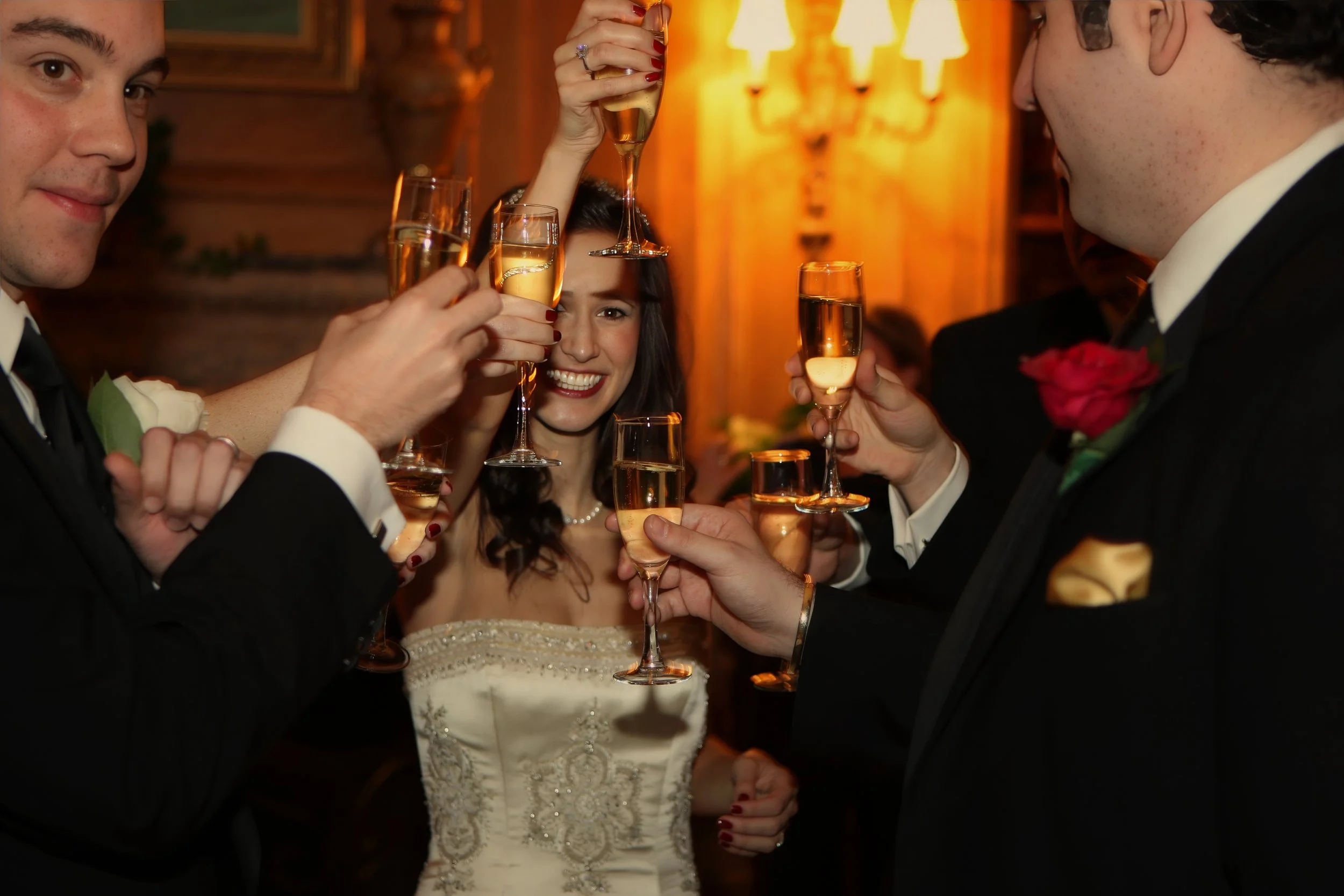 Bride raising a glass with friends during a joyful moment at an Oheka Castle wedding reception