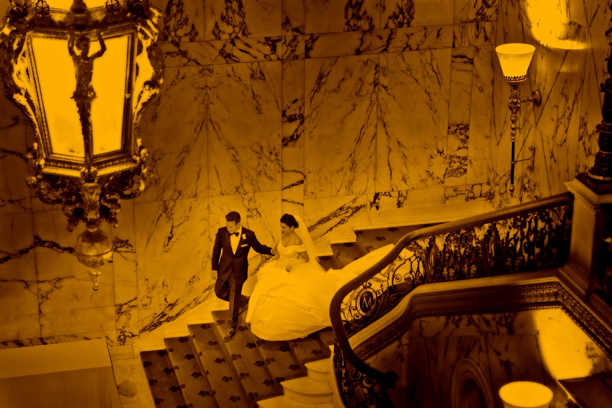 Bride and groom descending the grand staircase at the Metropolitan Club New York City wedding photograph