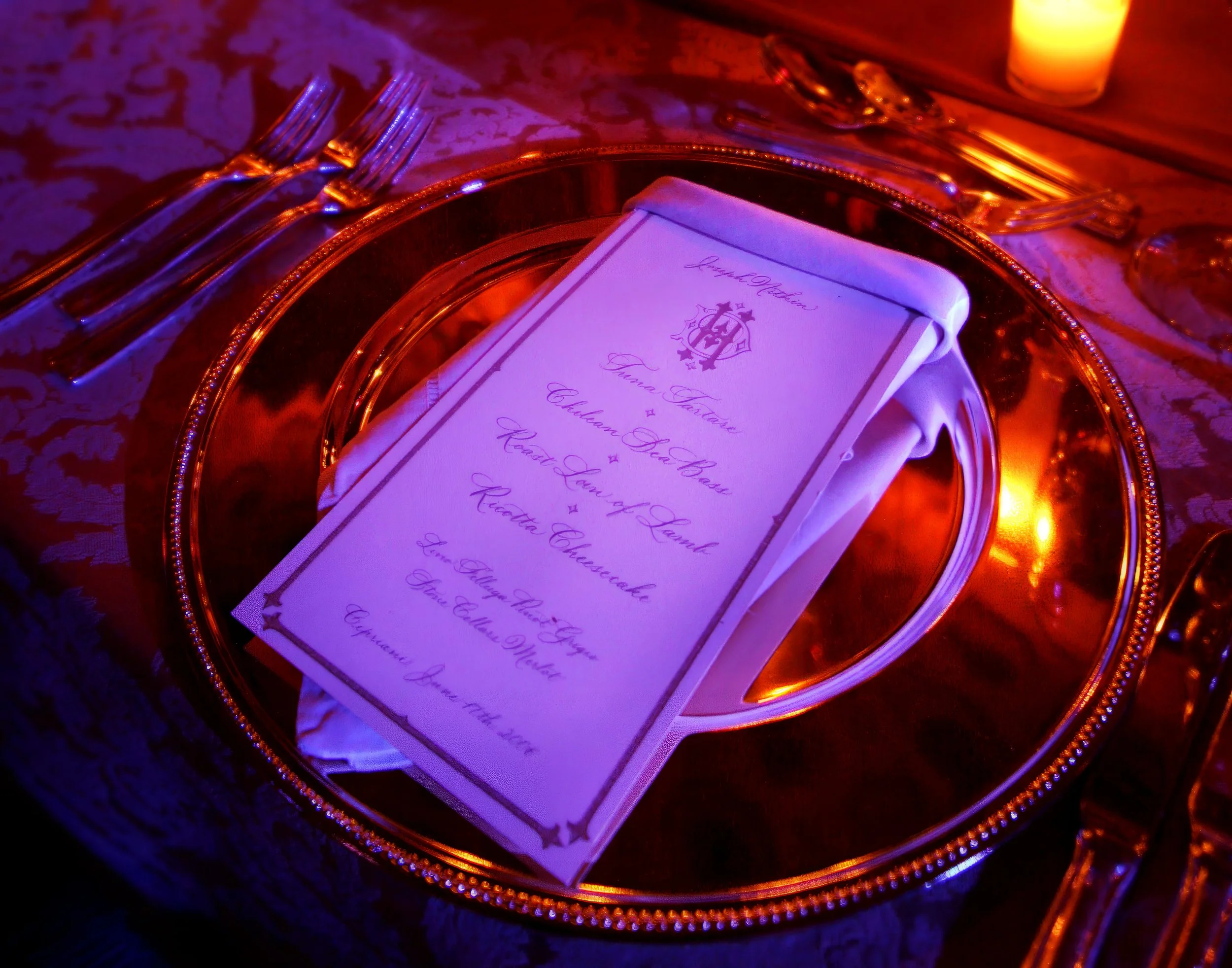 Elegant place setting and menu at Cipriani Wall Street wedding reception in gold and blue light NYC.