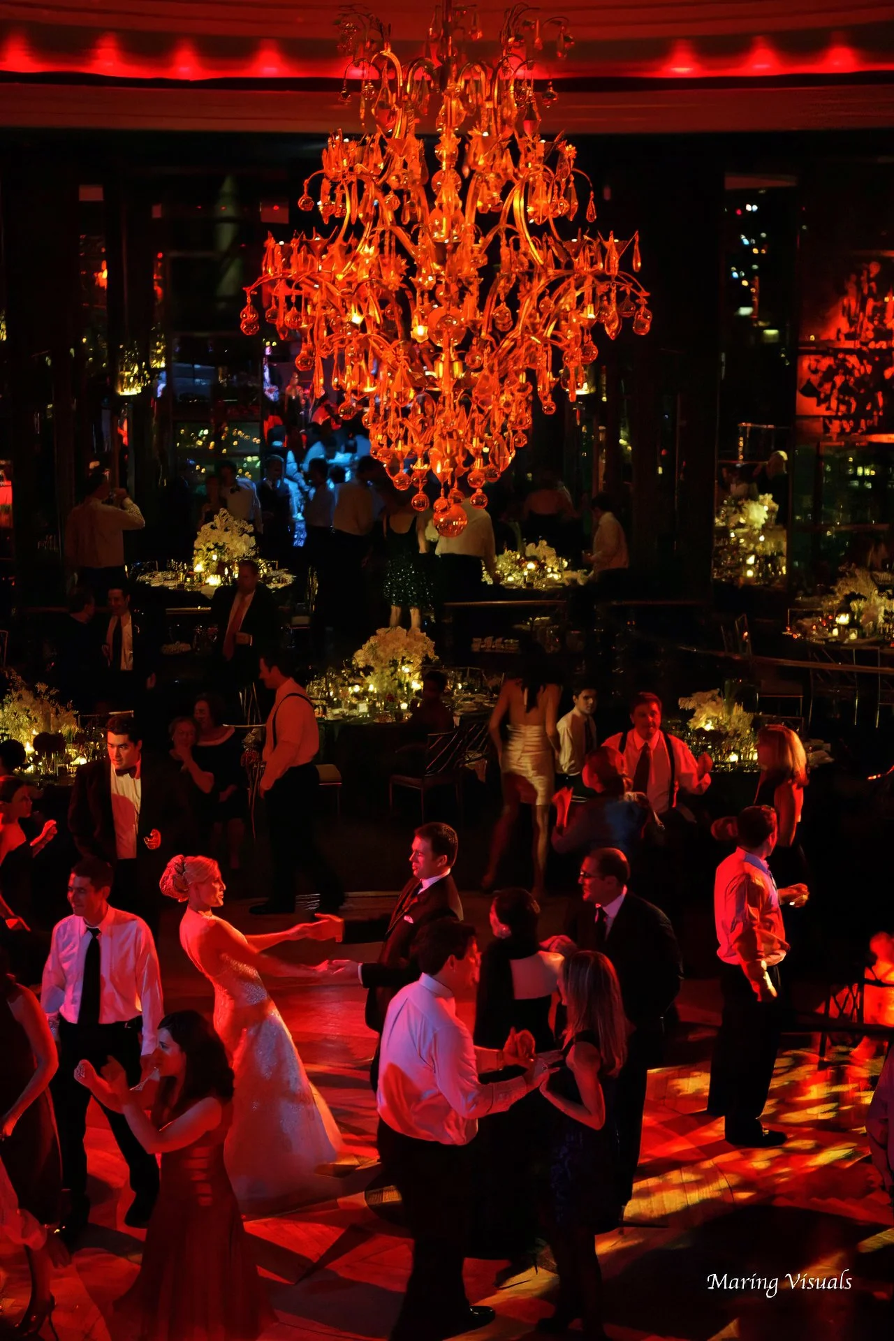 Bride and groom dance beneath red lighting on the Rainbow Room wedding reception dance floor in New York City.