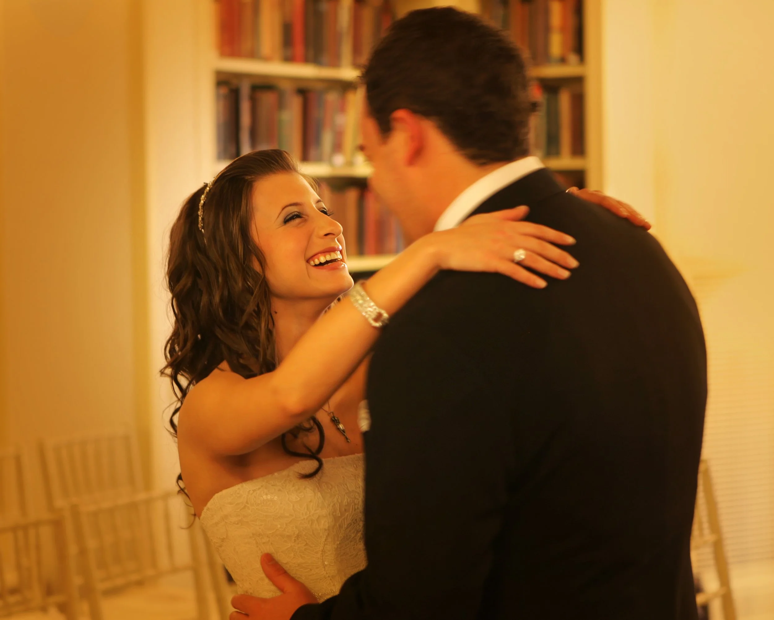 Bride and groom share a romantic first look in the historic library at the Yale Club NYC surrounded by wood paneling and bookshelves.